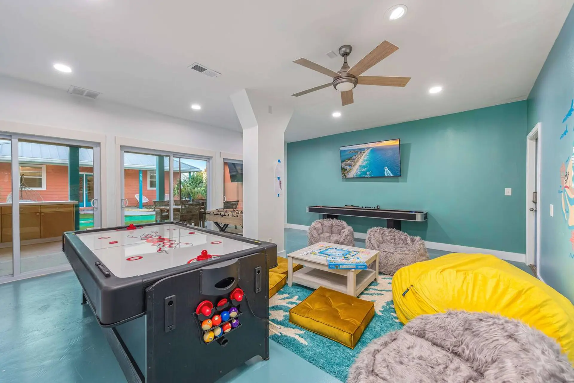 A game room with air hockey and shuffleboard tables.