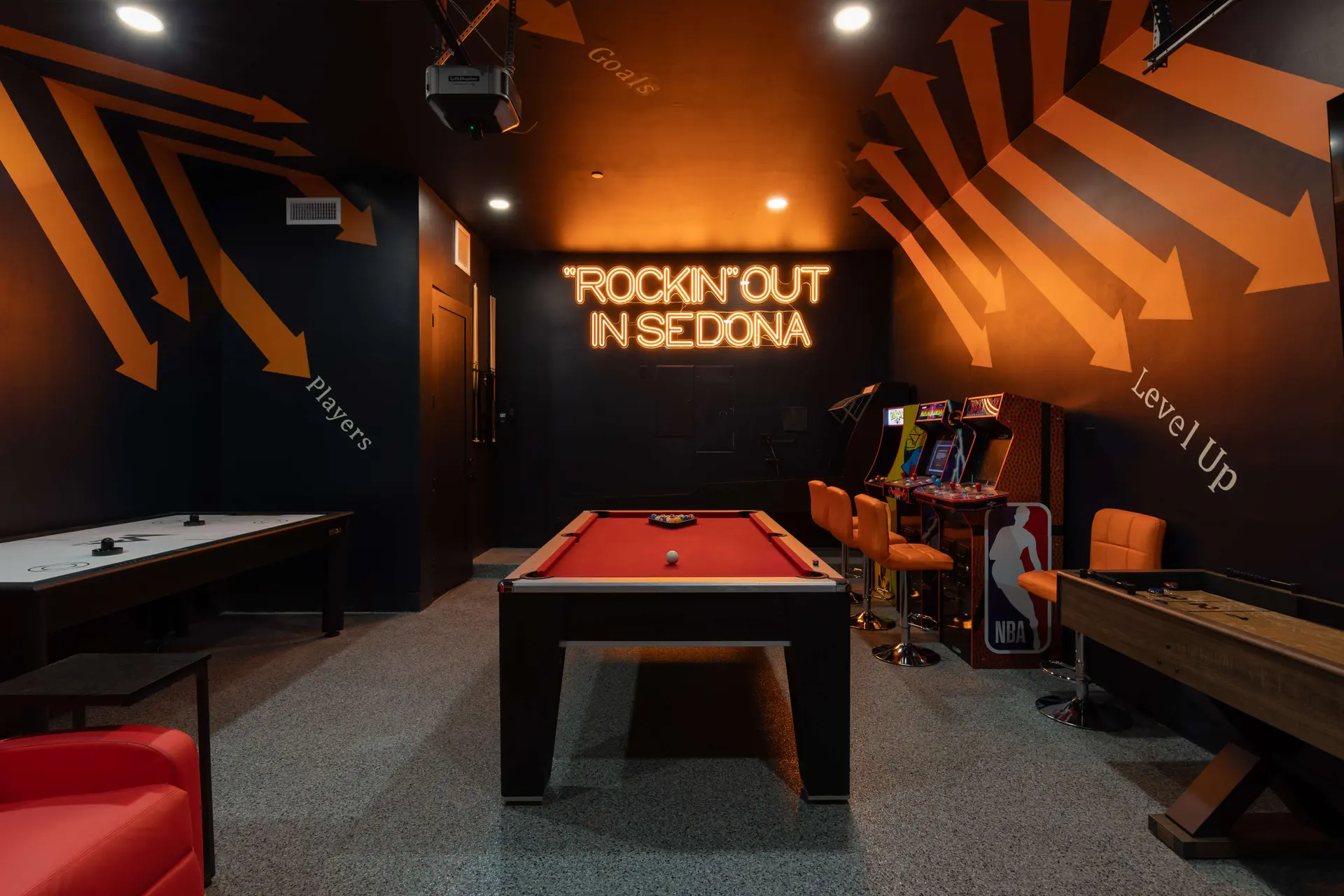 Neon sign in a game room that says "ROCKIN' OUT IN SEDONA."