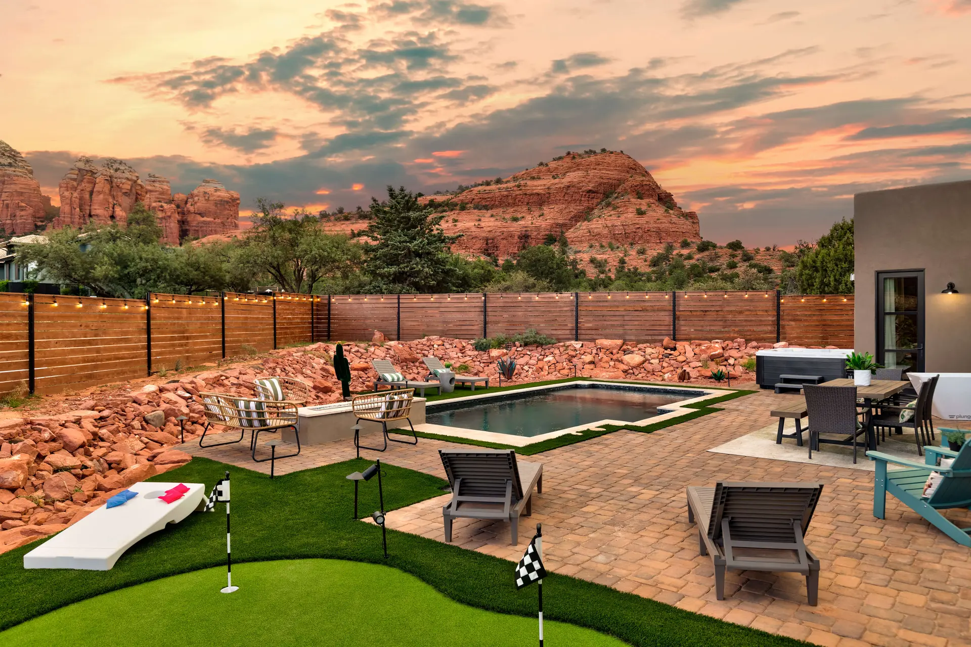 Backyard with pool and spa with red rock formations in the background.