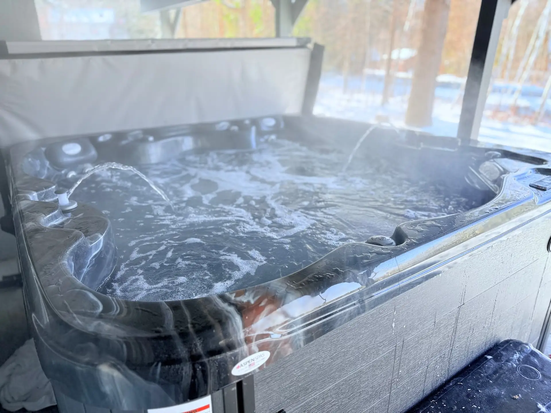 A steaming hot tub in a snowy outdoor setting.