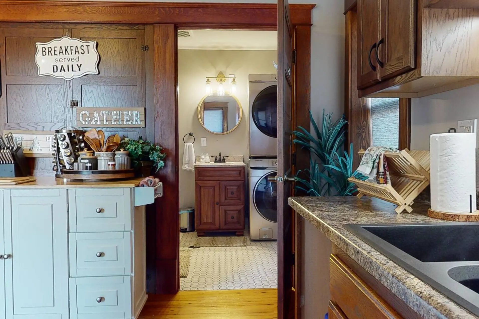 A kitchen and laundry room with a sink, cabinets, and appliances.