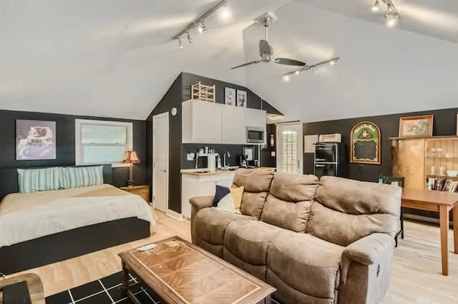 A studio apartment with a bed, sofa, coffee table, kitchen, and dining table.