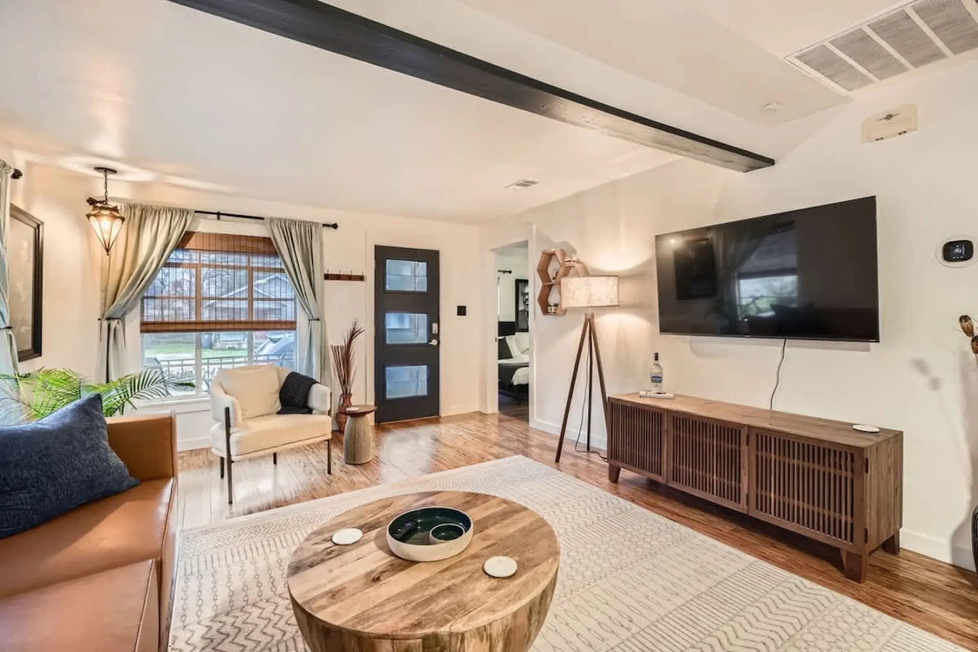 A living room with a leather sofa, a plush chair, a tv, and a wooden coffee table.