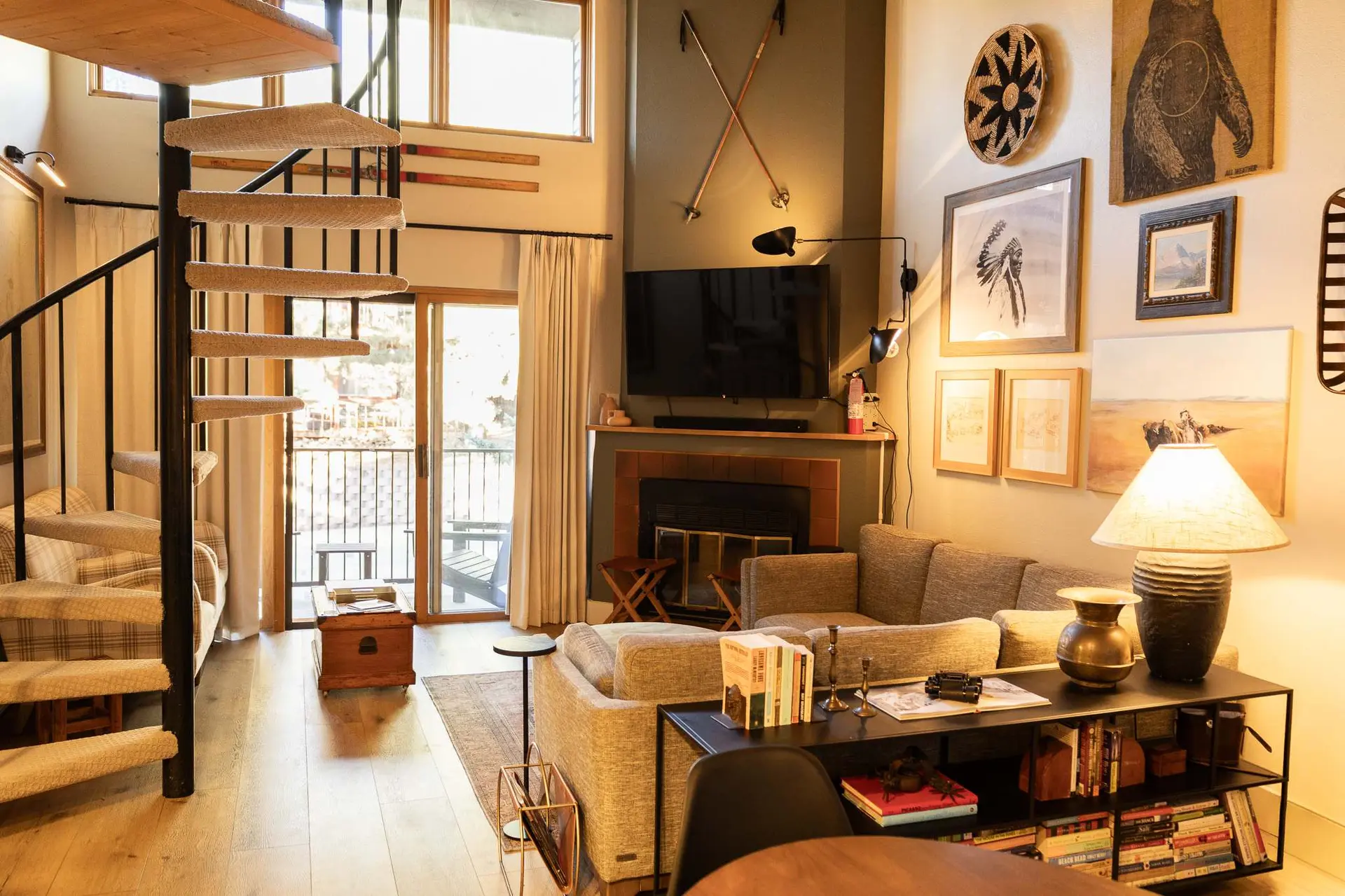 Living room with spiral staircase, fireplace, and cozy seating area.