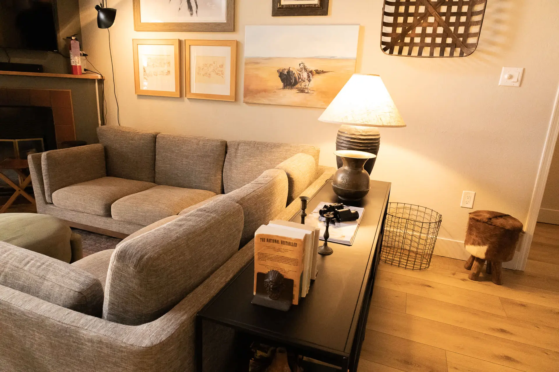 A living room with a sofa, lamp, and artwork on the wall.