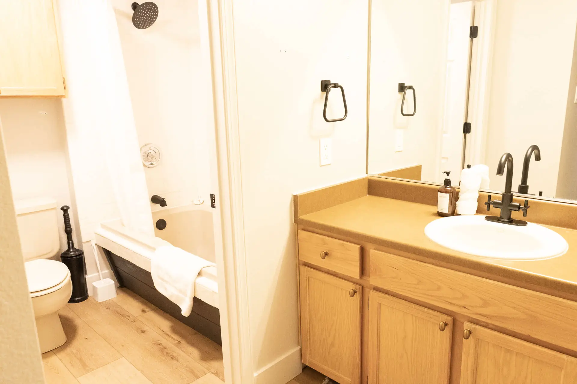 Bathroom with a toilet, bathtub, and sink vanity.