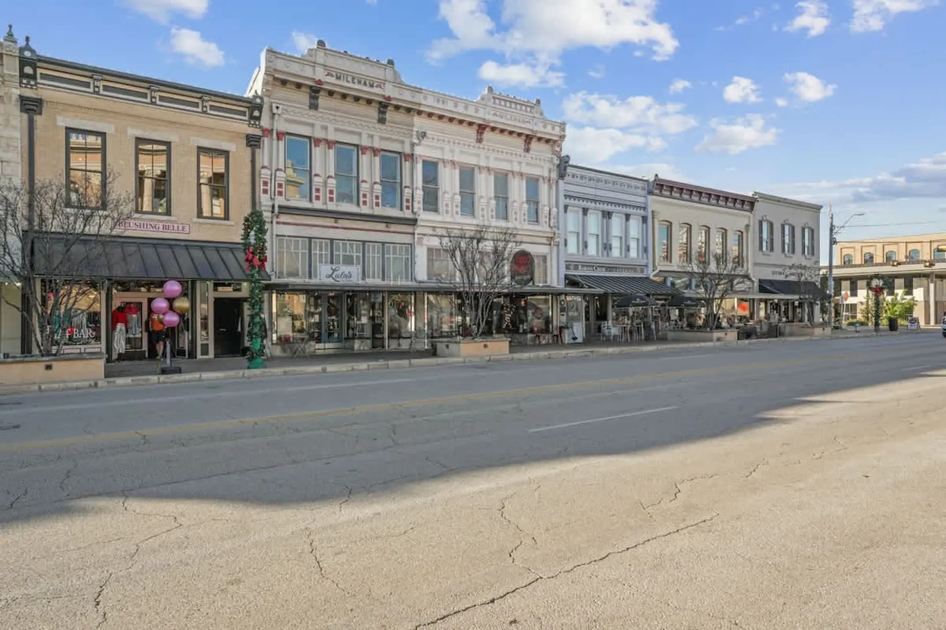 A charming street view of historic buildings with storefronts and awnings.