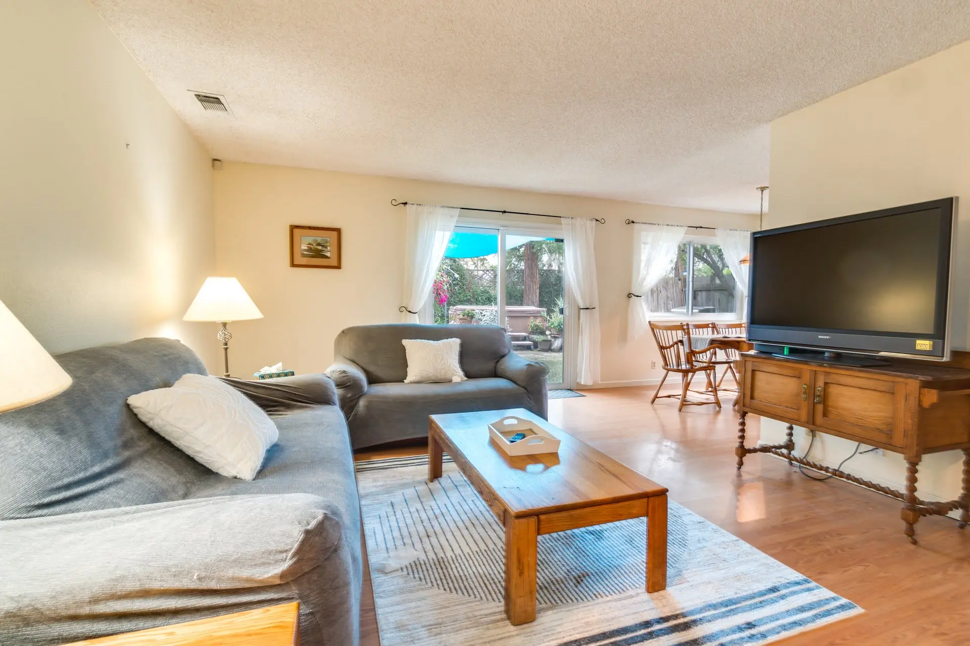 Living room with gray sofas, a coffee table, and a television on a wooden cabinet.
