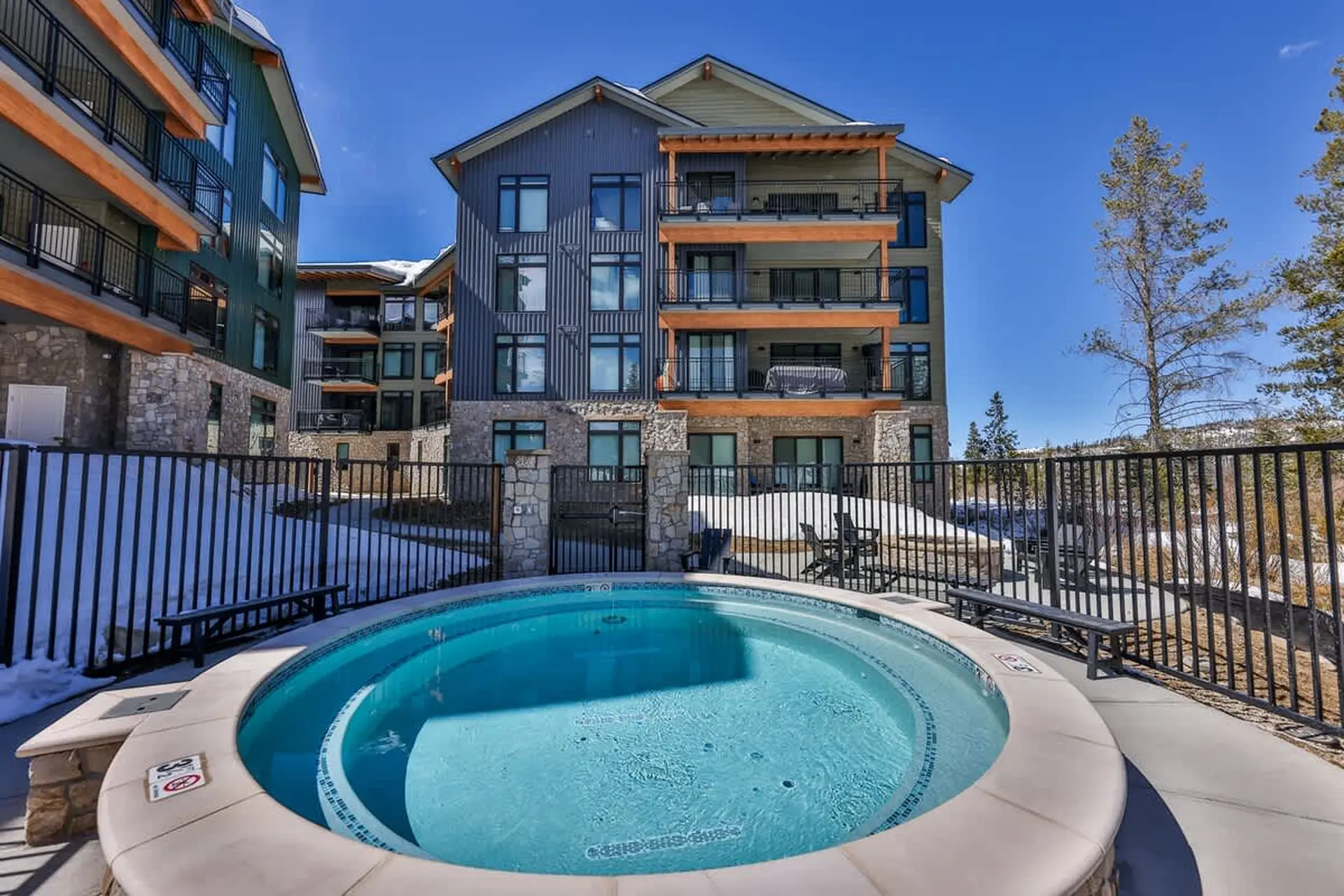 An outdoor hot tub is in the foreground, with apartment buildings in the background.