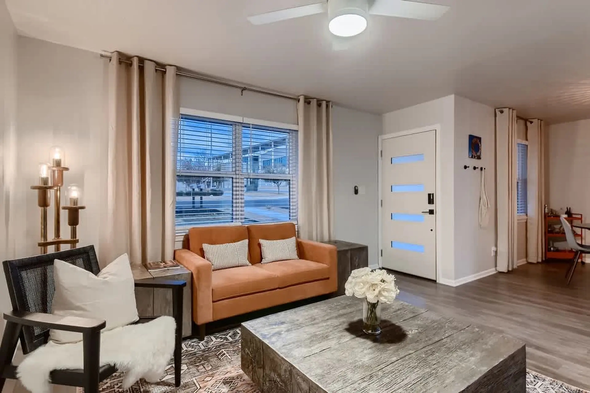 A modern living room with a velvet couch, faux fur chair, and coffee table.