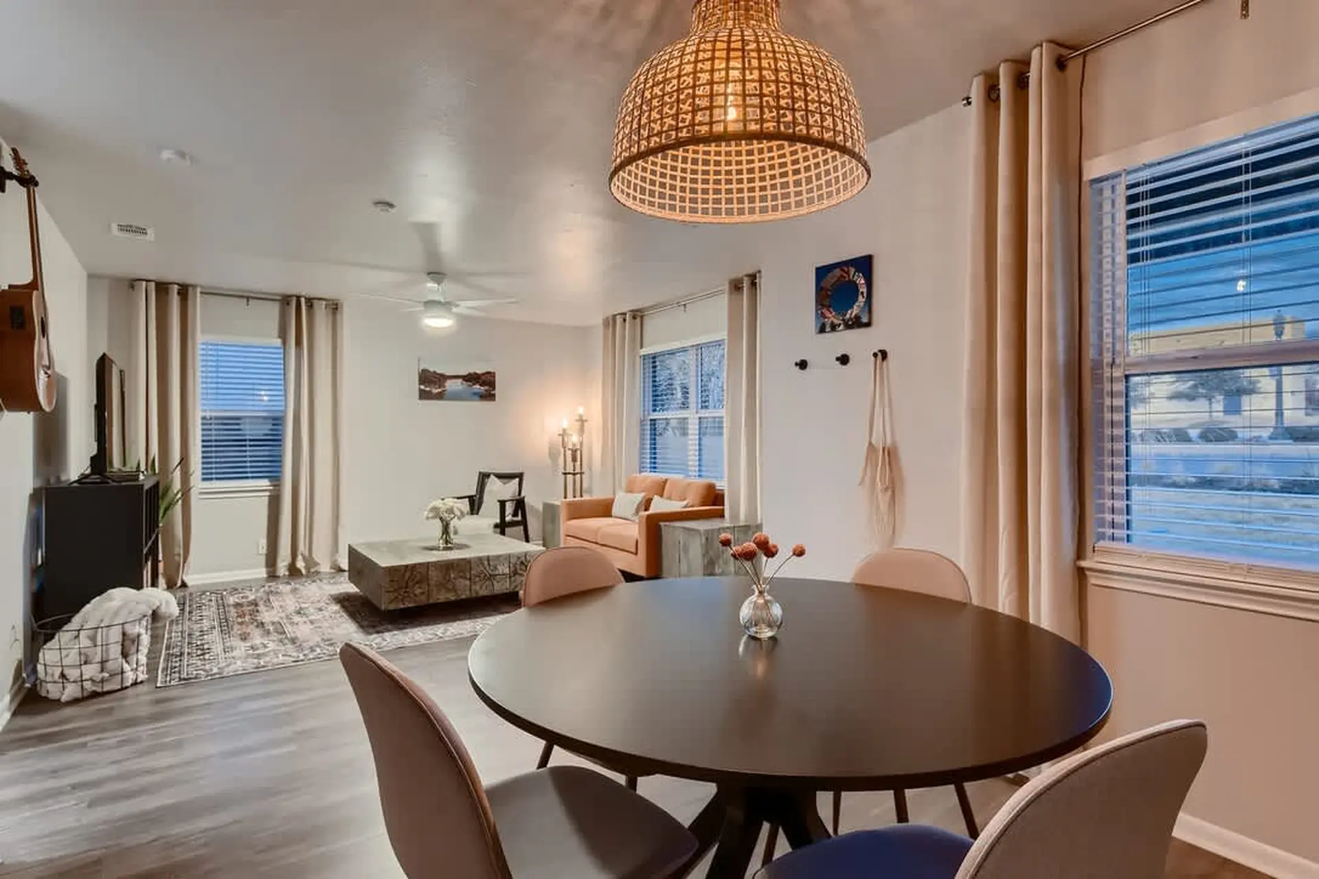 A round dining table with chairs sits in front of a window.