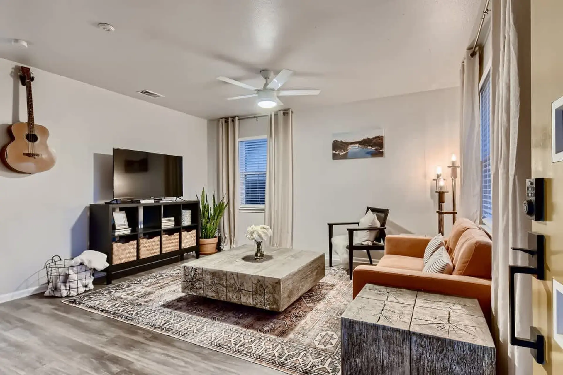 Living room with a guitar, TV, couch, and coffee table.