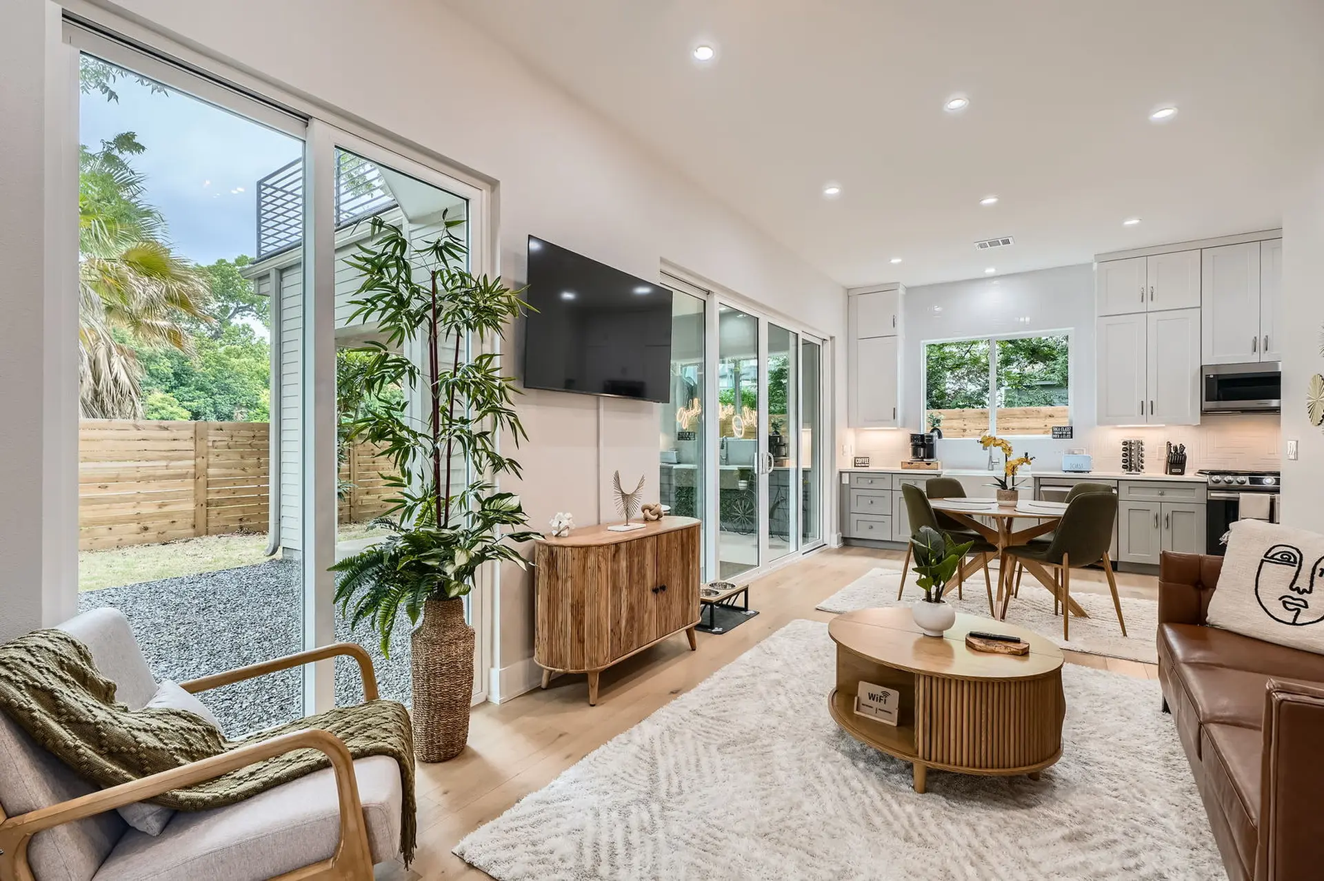 Modern living room with sliding glass doors, plush rug, and minimalist furniture.