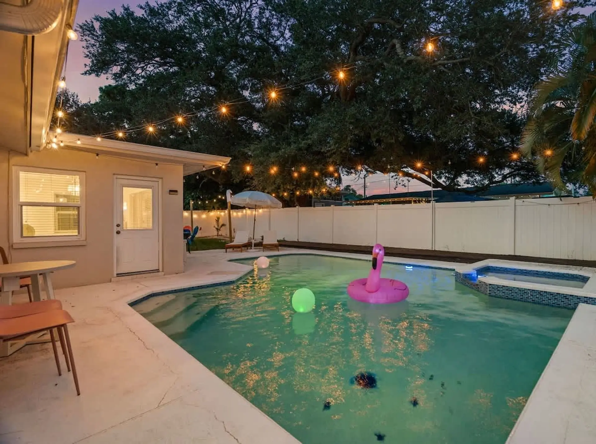 Backyard swimming pool with a flamingo float at twilight.