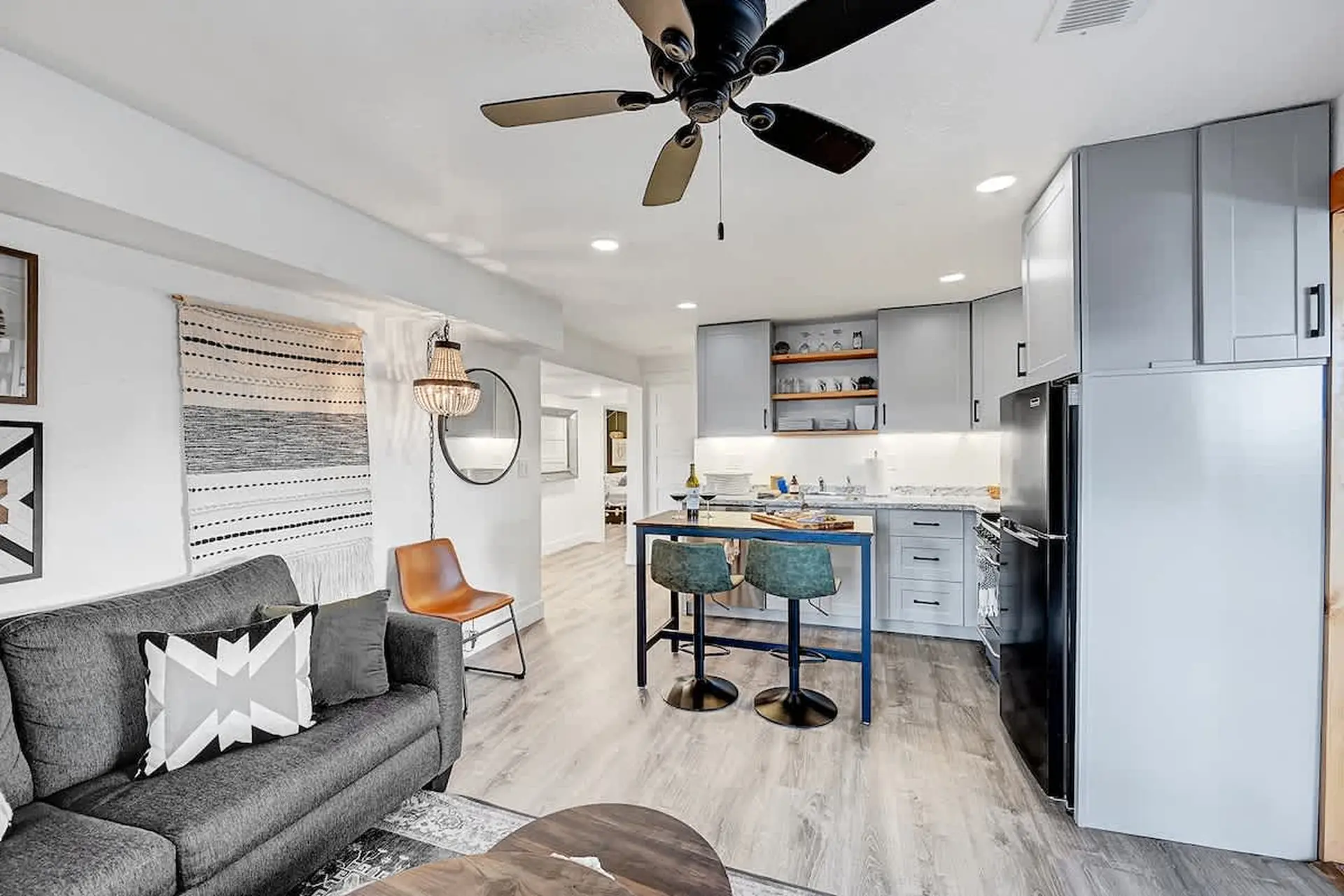 A modern studio apartment with a couch, kitchen, and dining area.