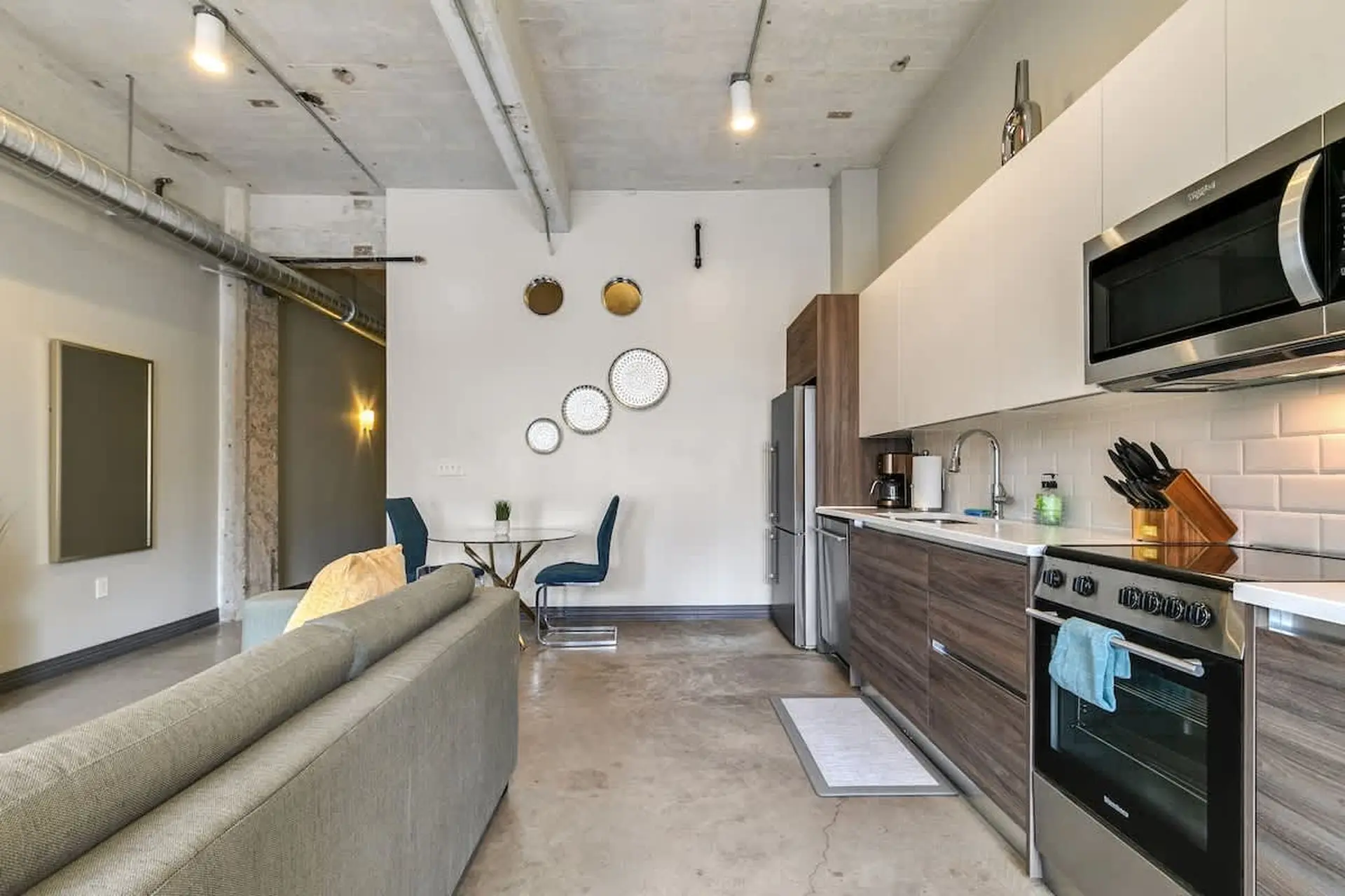 Loft apartment with exposed concrete, living area, and modern kitchen.