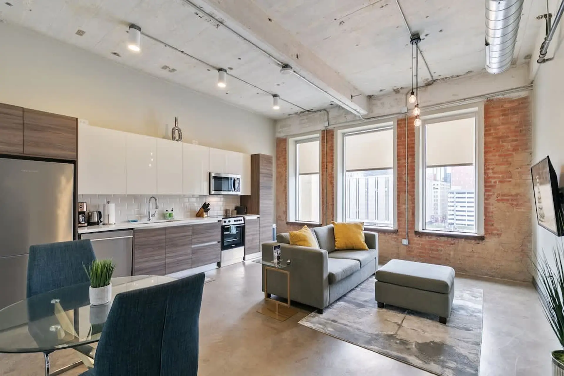 Living room with kitchen, sofa, and dining table.