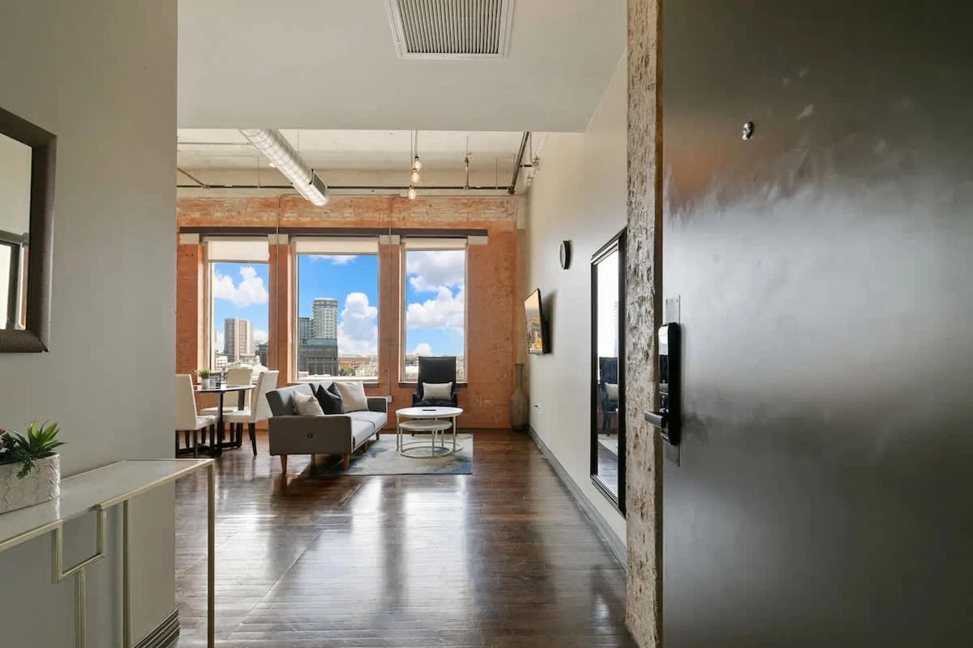 Interior of a modern apartment with city views and exposed brick.