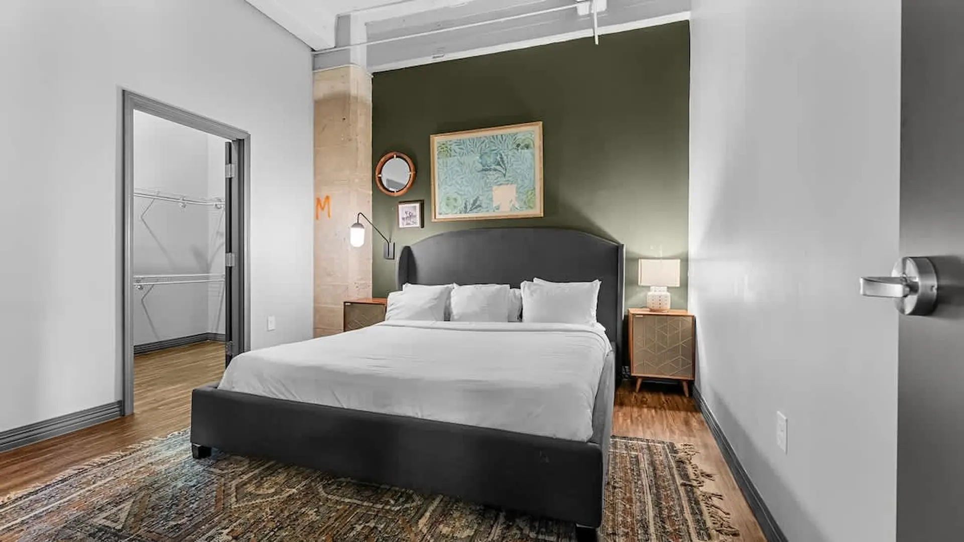 Modern bedroom with a queen-size bed, dresser, and walk-in closet.