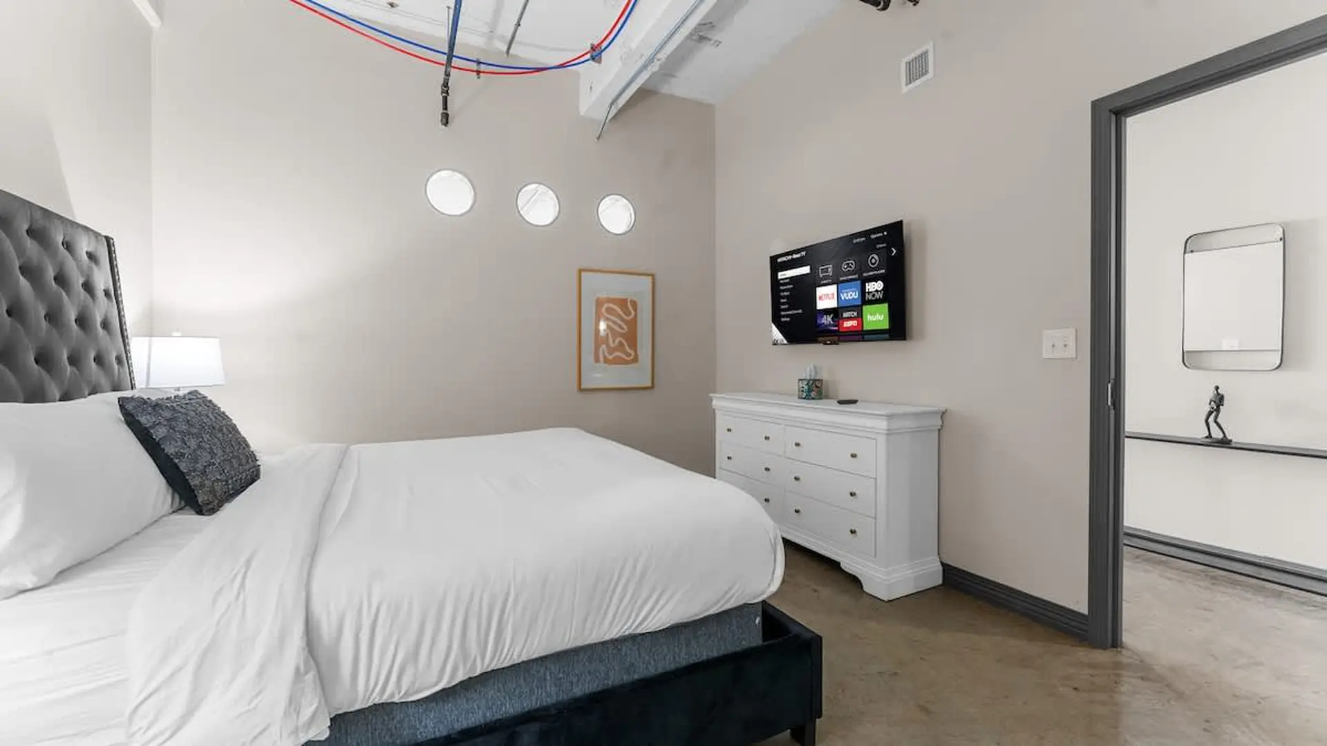 Bedroom with a large bed, a dresser, and a TV.