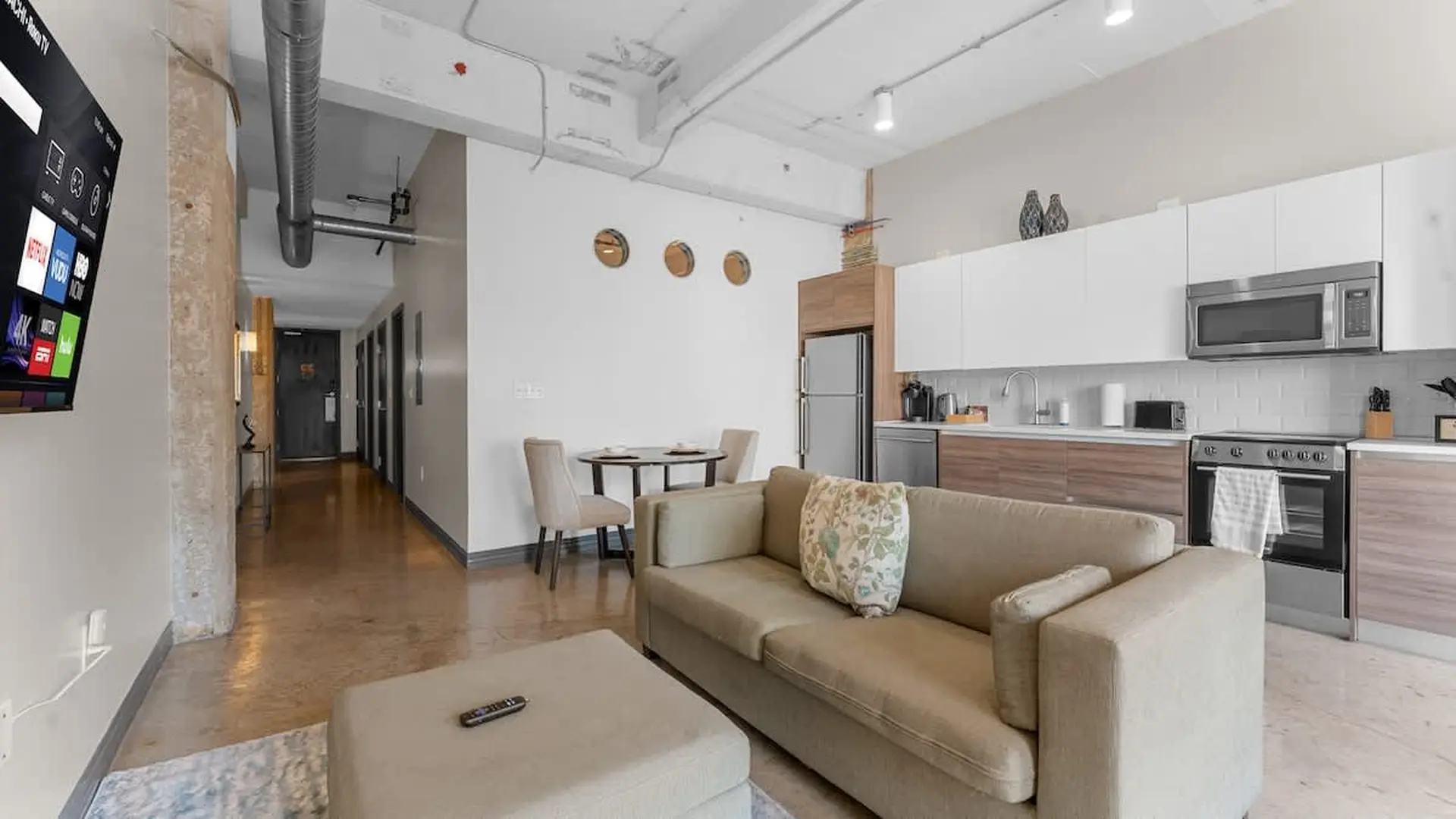 Modern studio apartment with open-concept living, dining, and kitchen area.