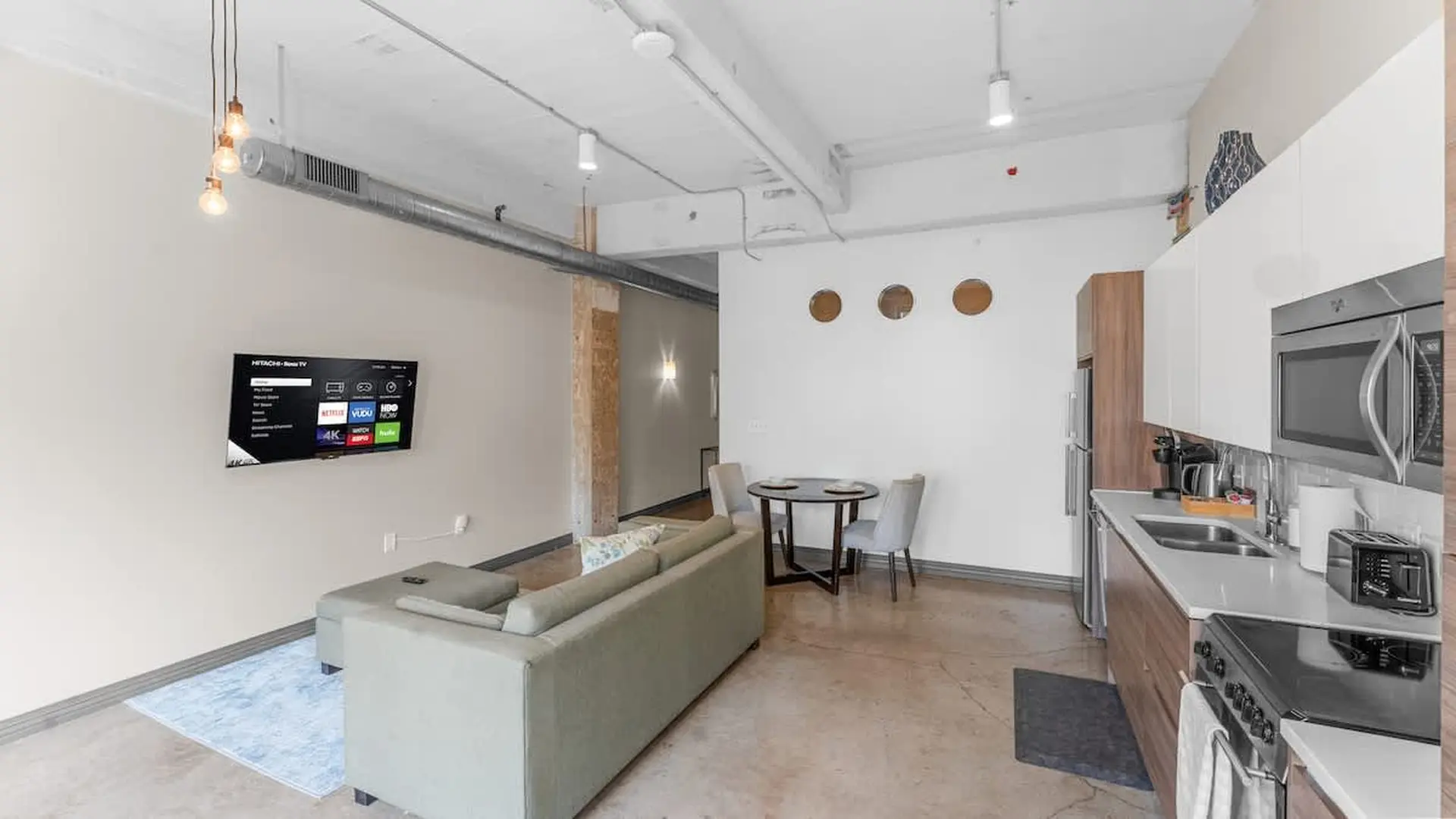 Living room and kitchen with modern appliances and decor.