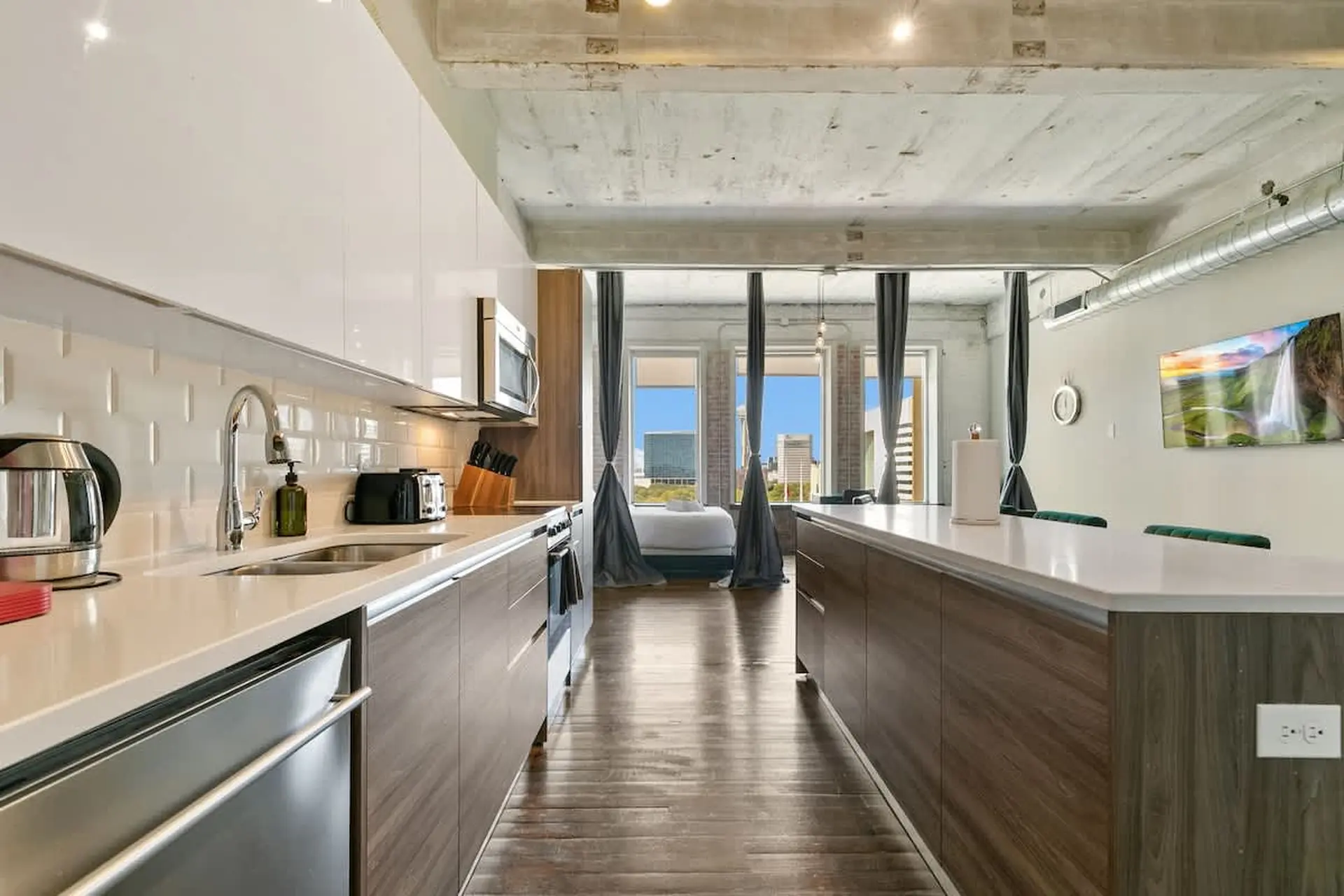 A modern loft apartment with a sleek kitchen and city views.