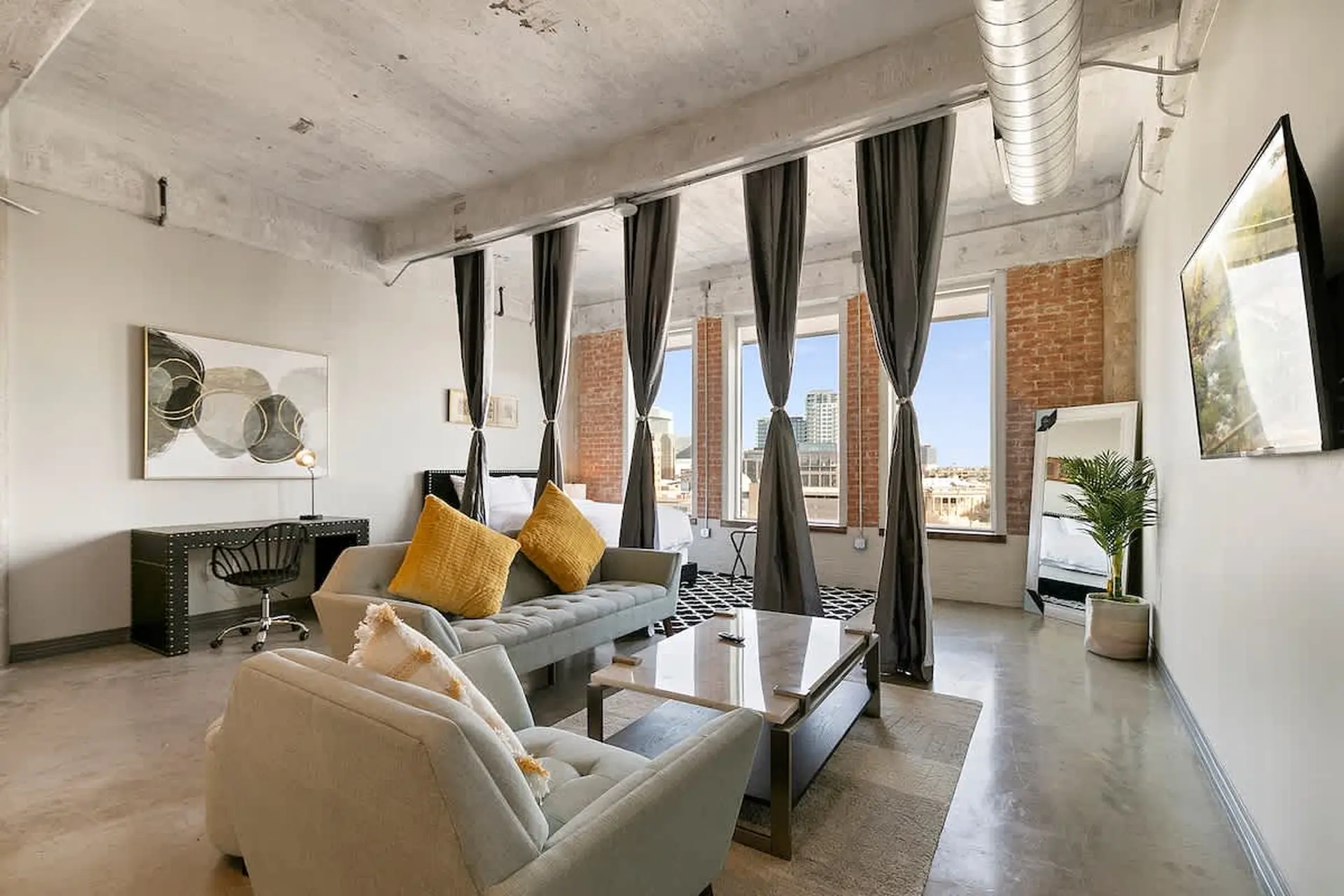 Loft apartment with modern decor, including a sofa, coffee table, and artwork.