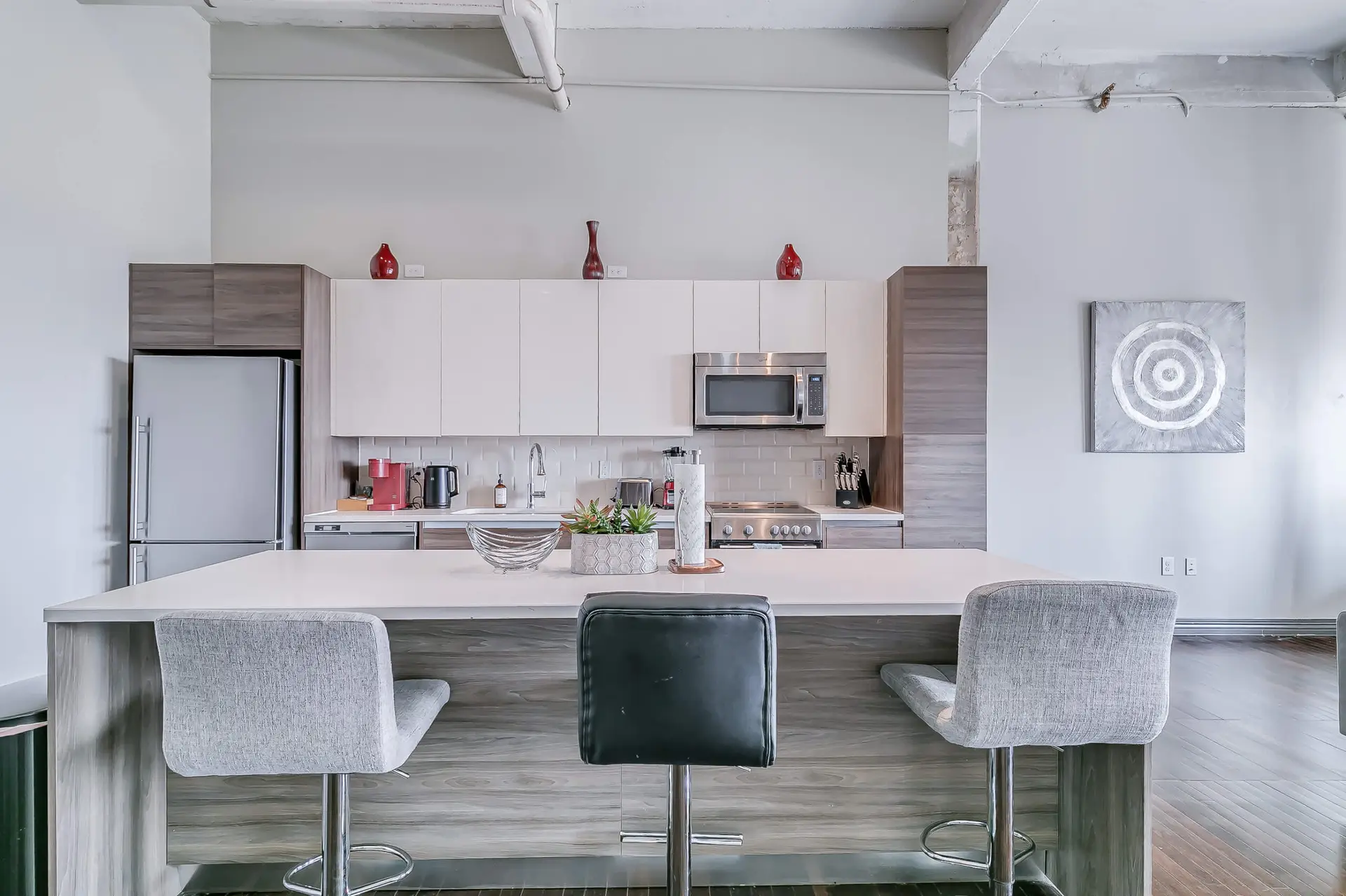 A modern kitchen island with bar stools and a sleek appliance wall.