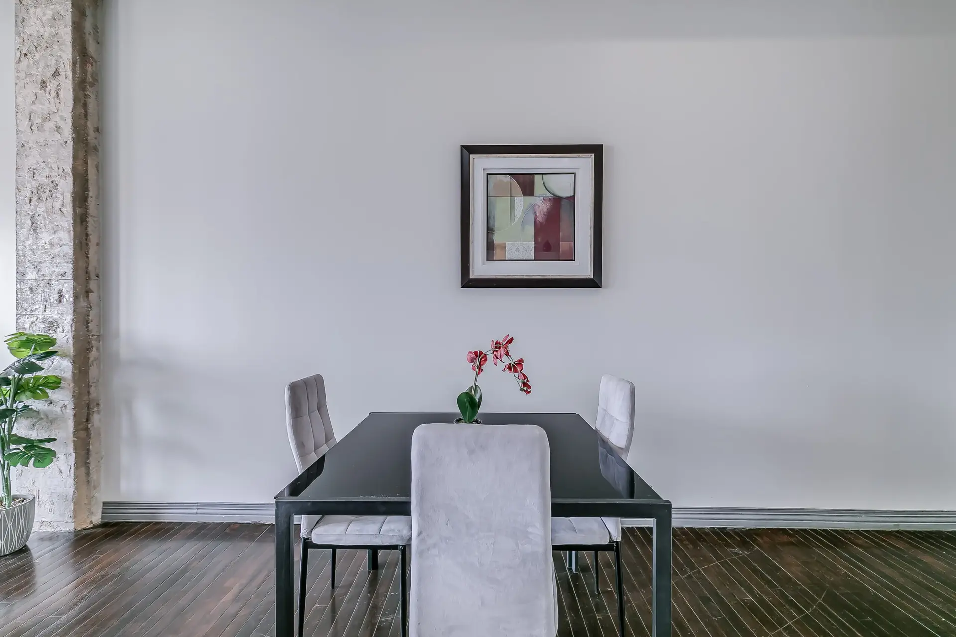 A dining table set with chairs and a floral arrangement is pictured.