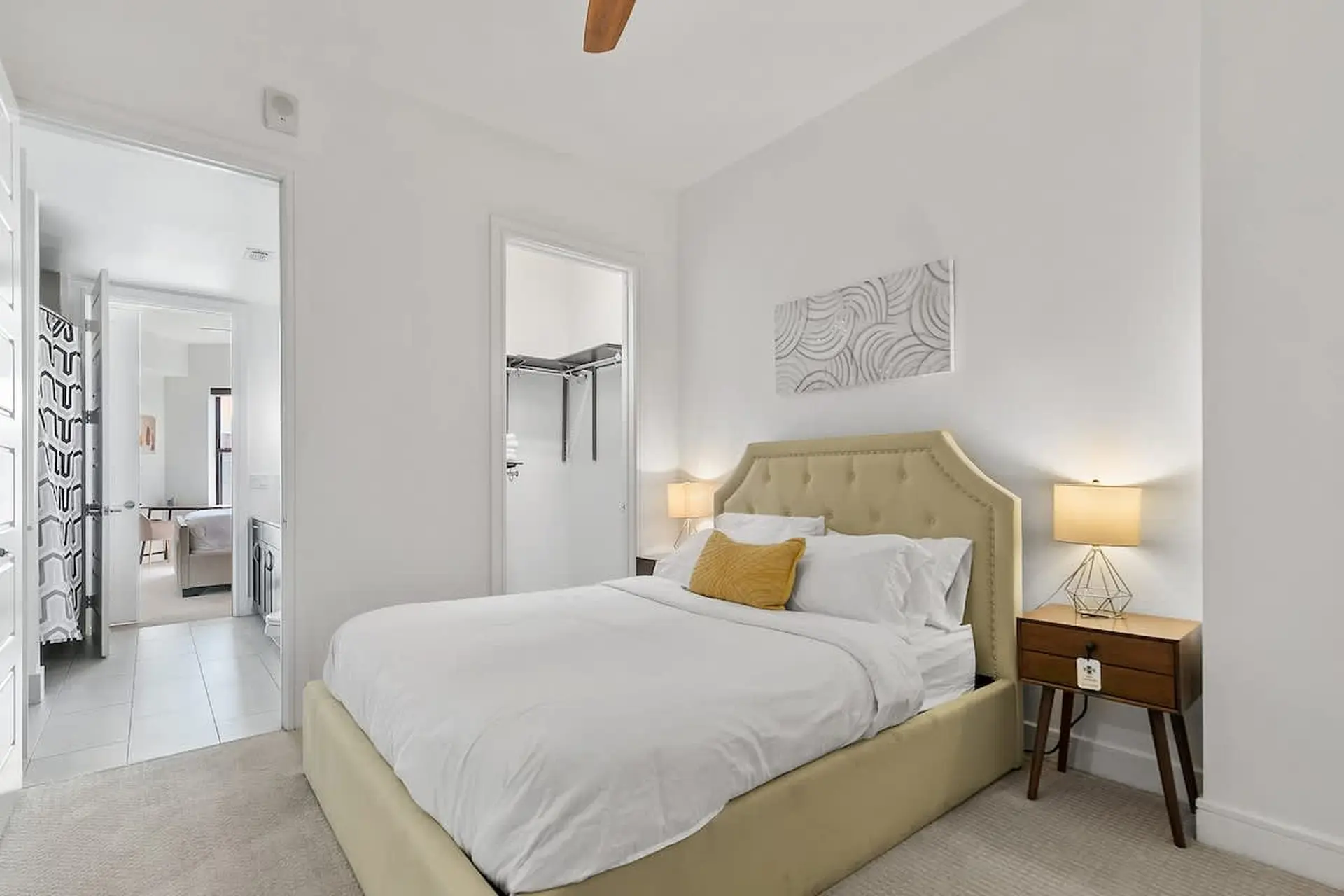 Modern bedroom with a white bed, yellow headboard, and a nightstand.
