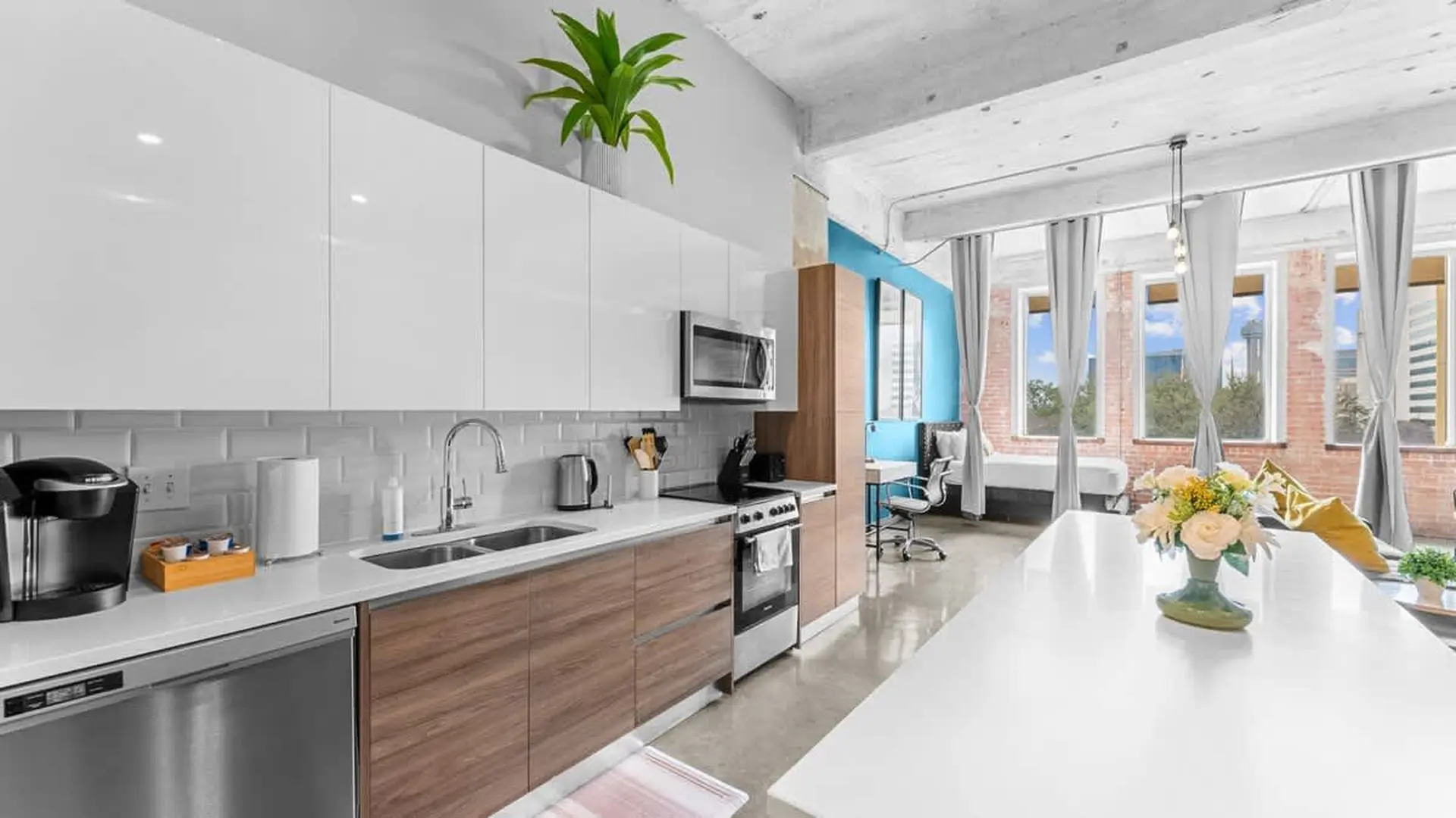 Kitchen with white cabinets, wooden drawers, and a stainless steel dishwasher.