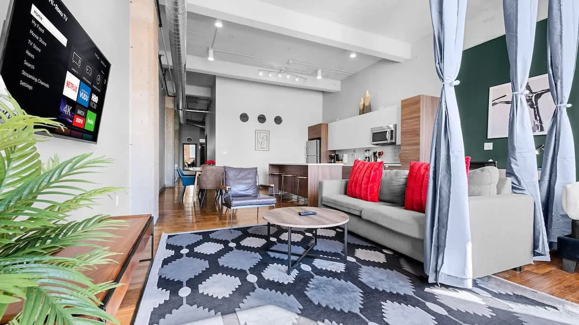 A modern living room with a couch, coffee table, and TV.