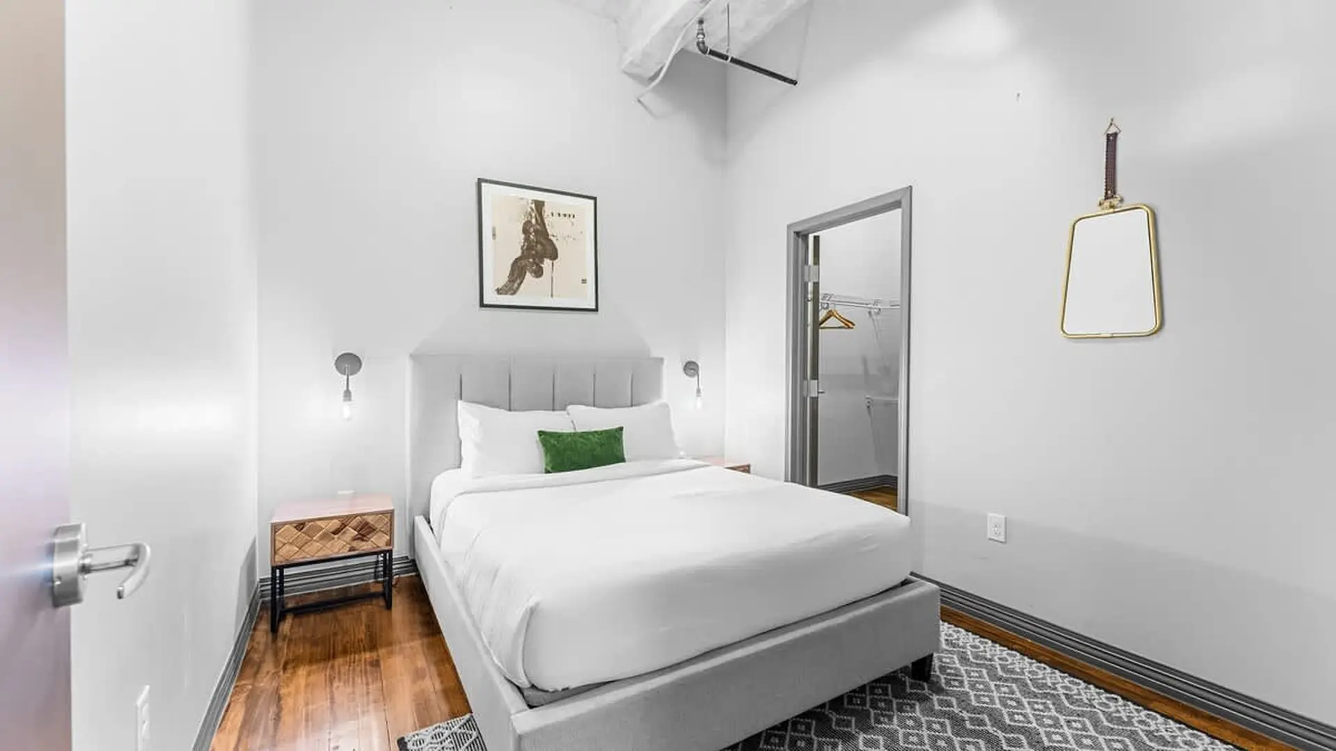A bright bedroom with a king-sized bed, minimalist decor, and a walk-in closet.