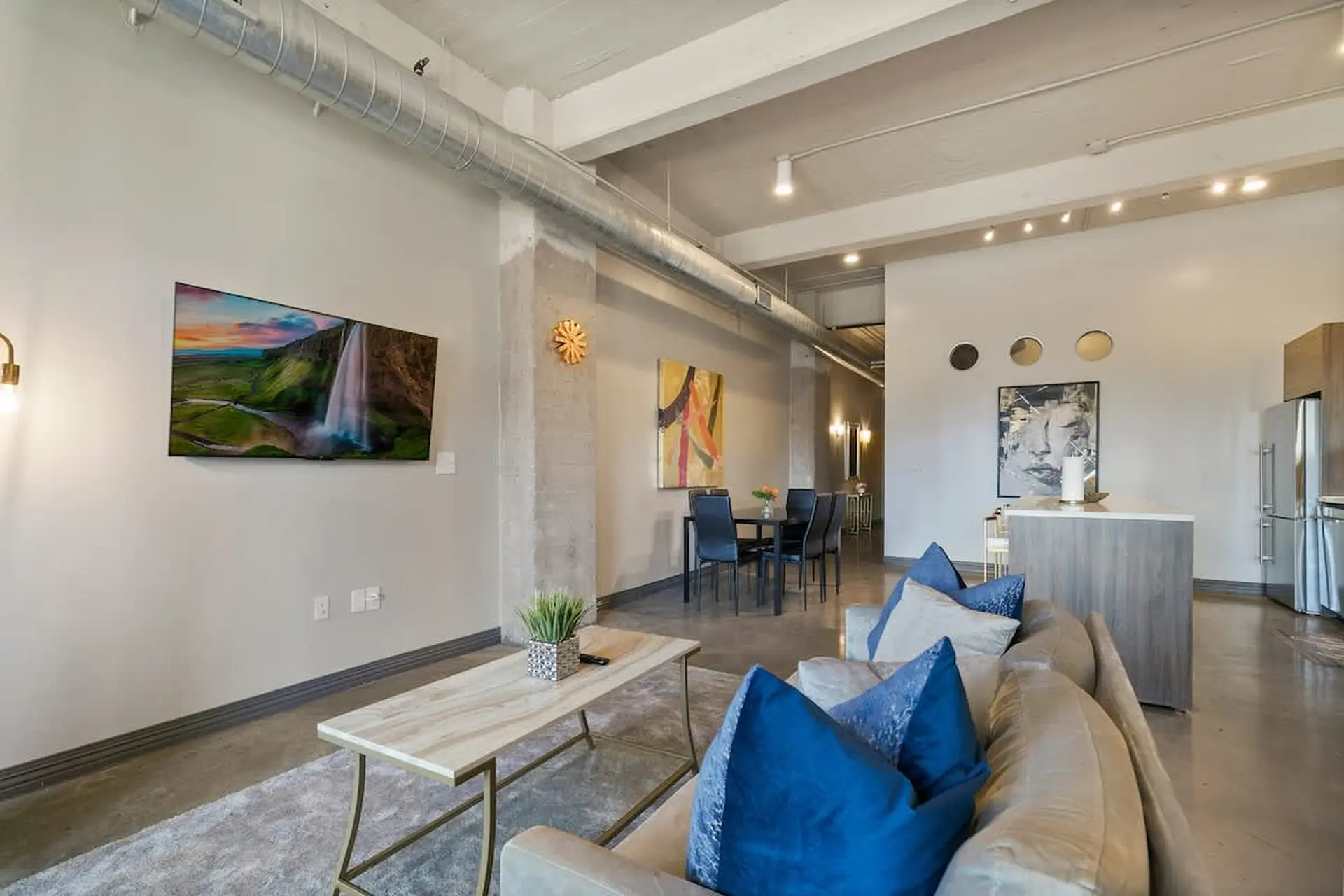 Living room with a couch, coffee table, TV, and dining area.