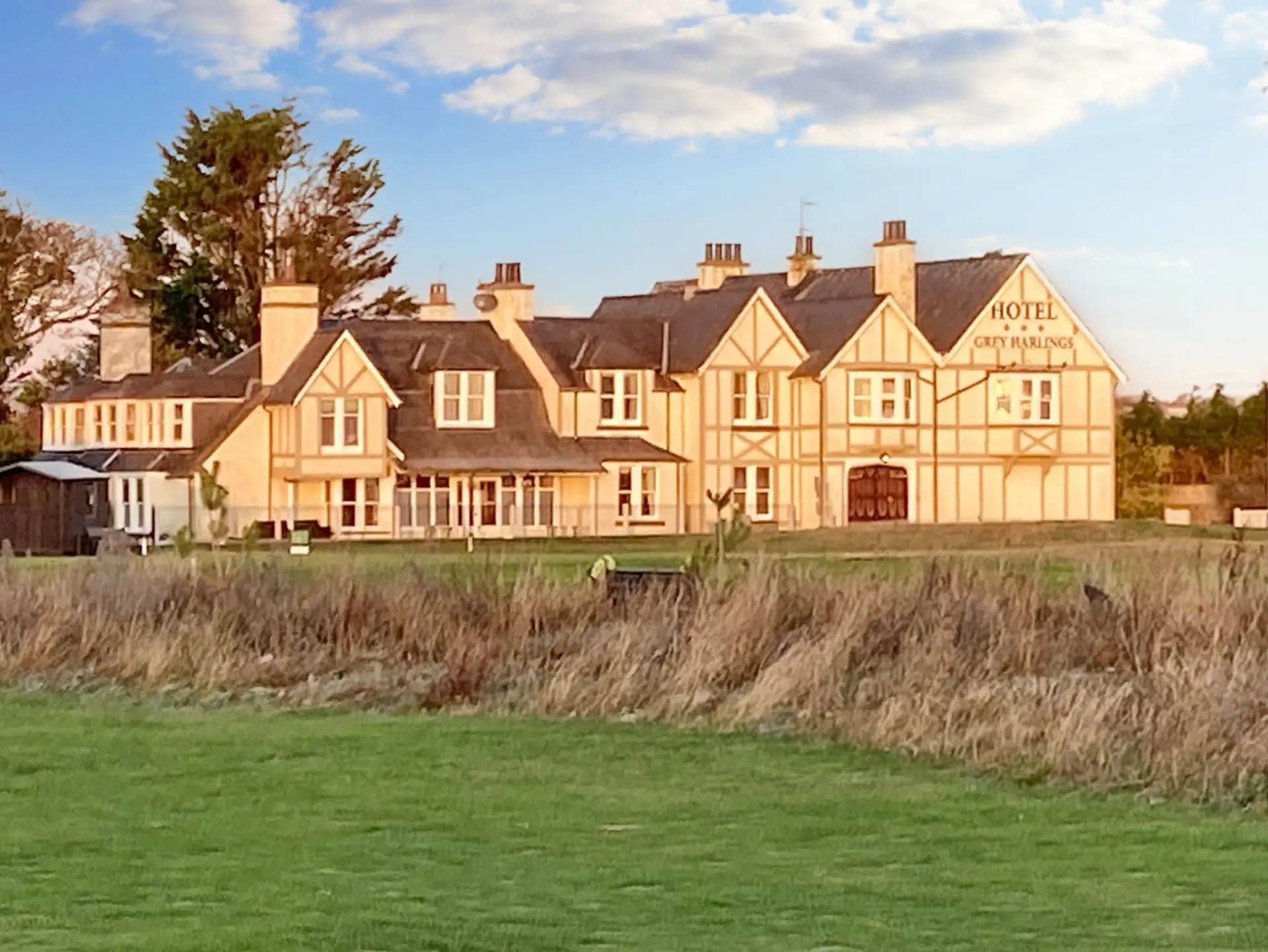 A hotel with a Tudor-style facade and the words "HOTEL GREY HARLINGS" on the front.