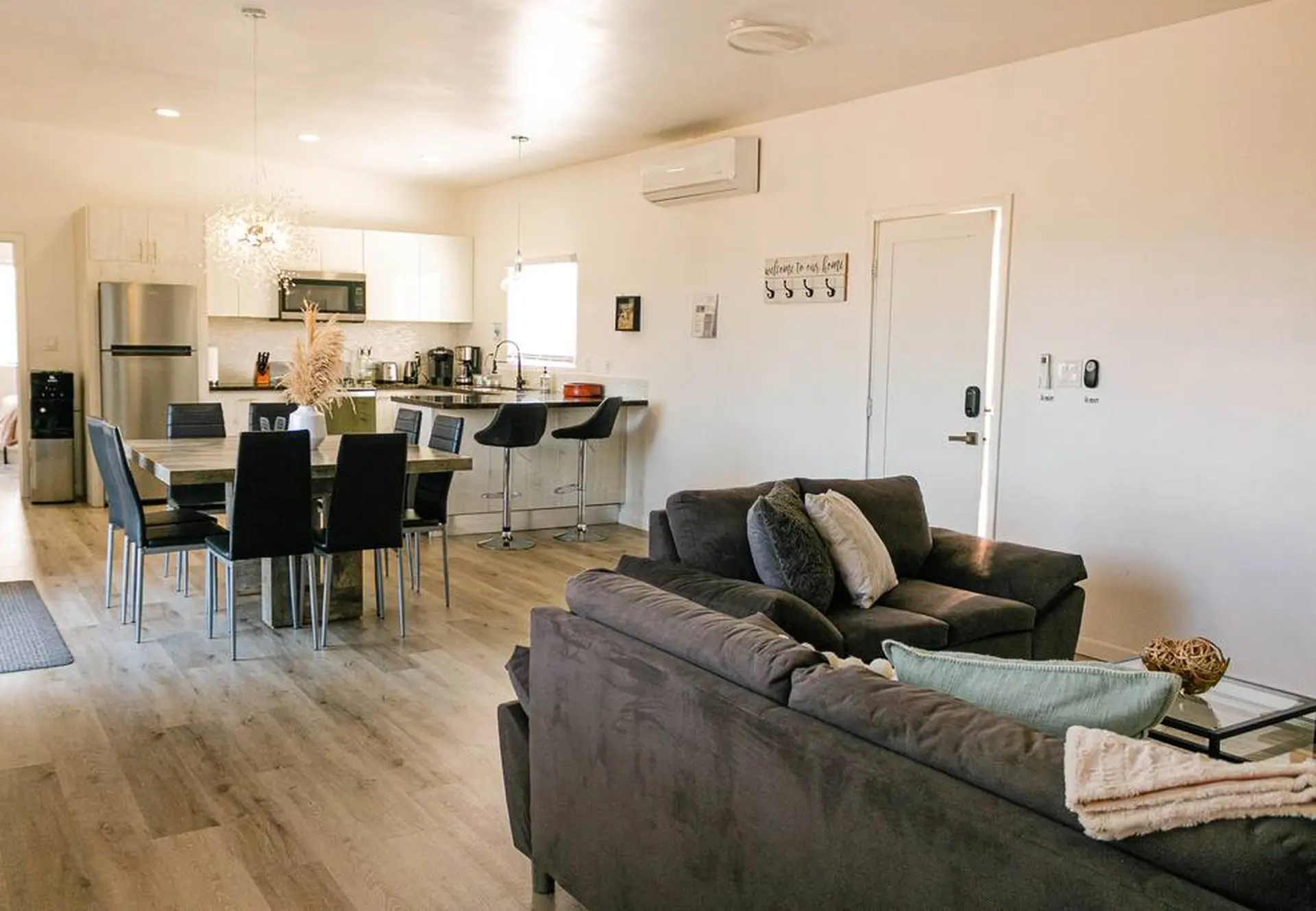 A modern living and dining room with a kitchen area.