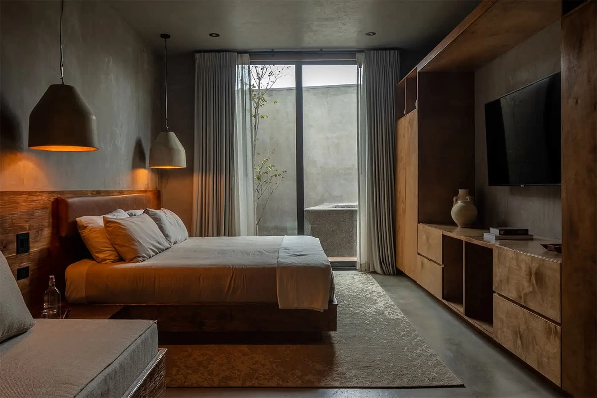 A cozy, modern bedroom with a king-size bed, bedside lamps, and a TV.
