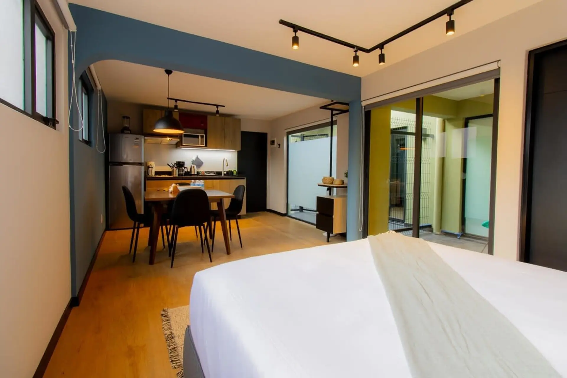 A stylish studio apartment with a kitchen, dining area, and bedroom.