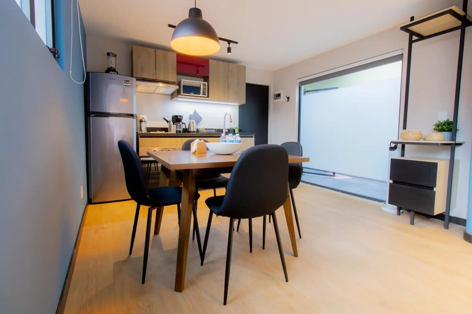 A dining set with four black chairs and a wooden table in a modern kitchen.