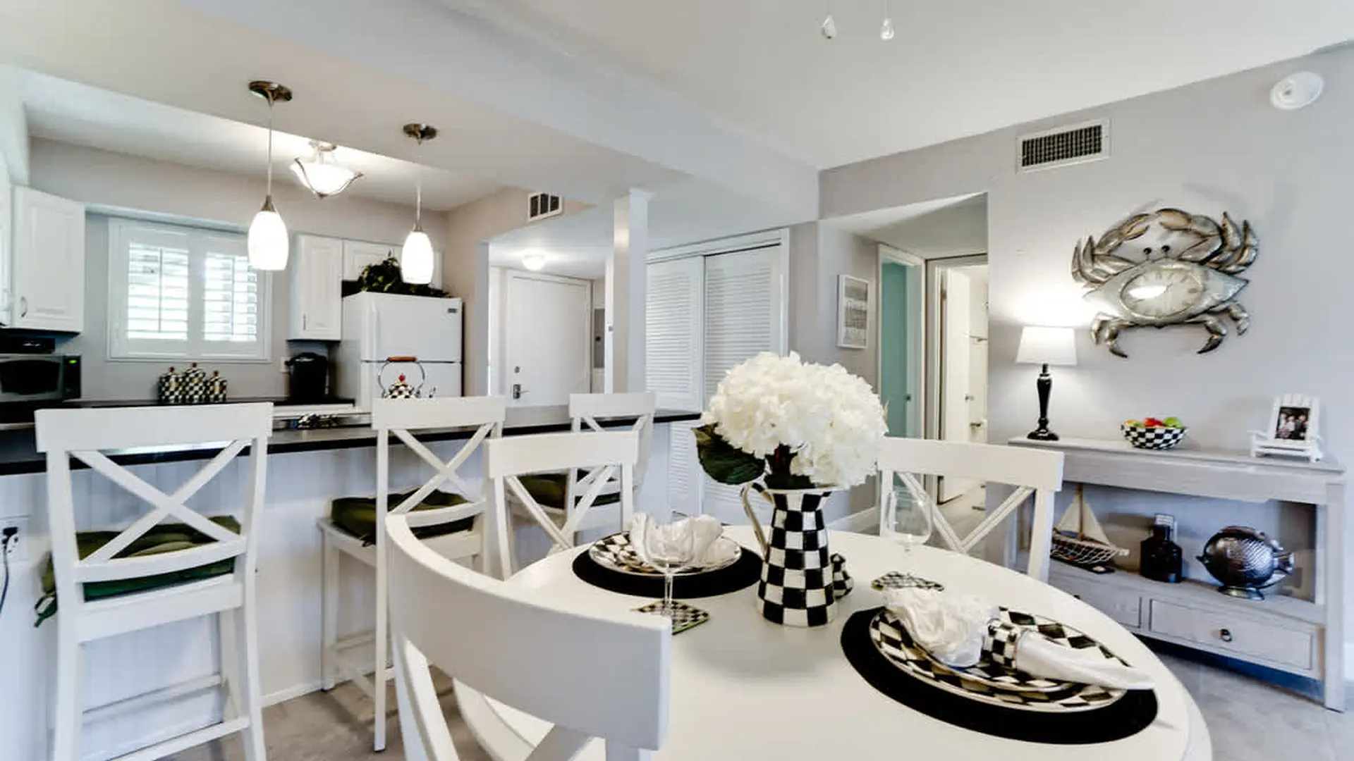 A dining room with white chairs and a white table.