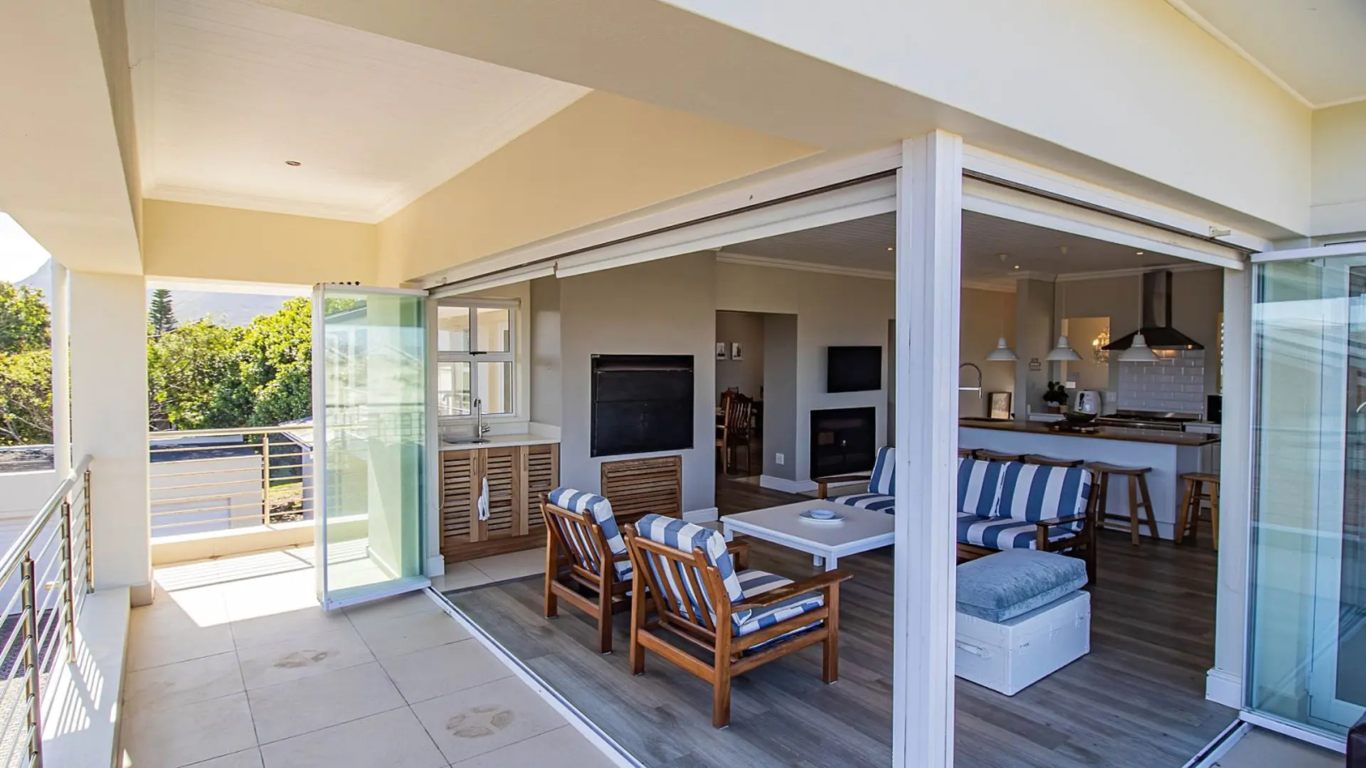 Modern open-plan living area with kitchen, dining, and outdoor lounge space.