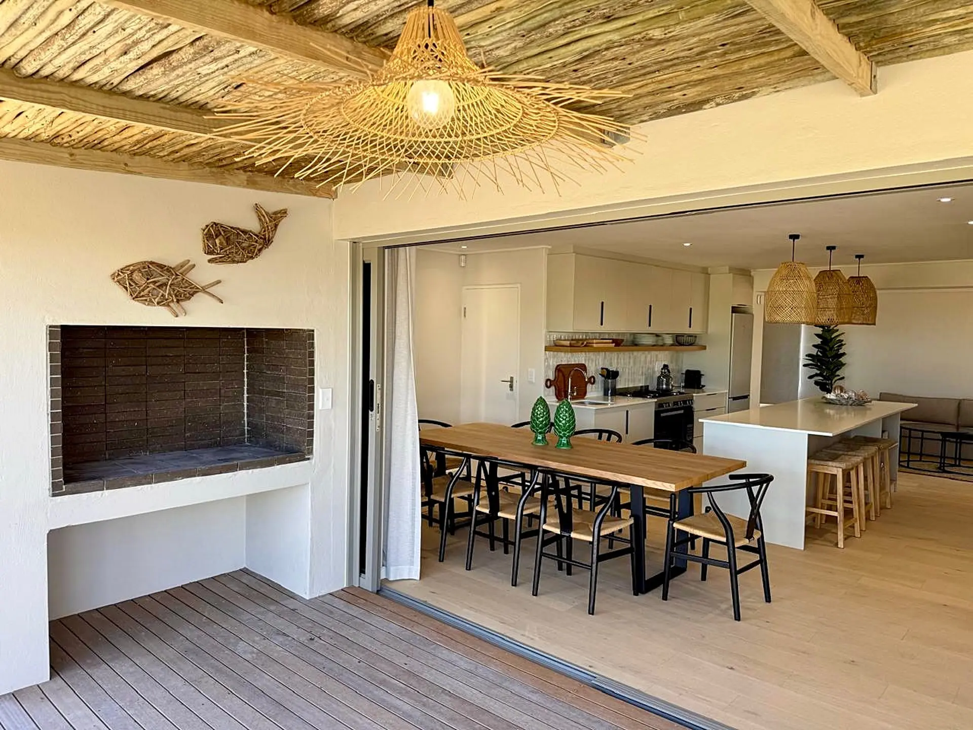 Outdoor patio with built-in grill, dining table, and kitchen area with island.