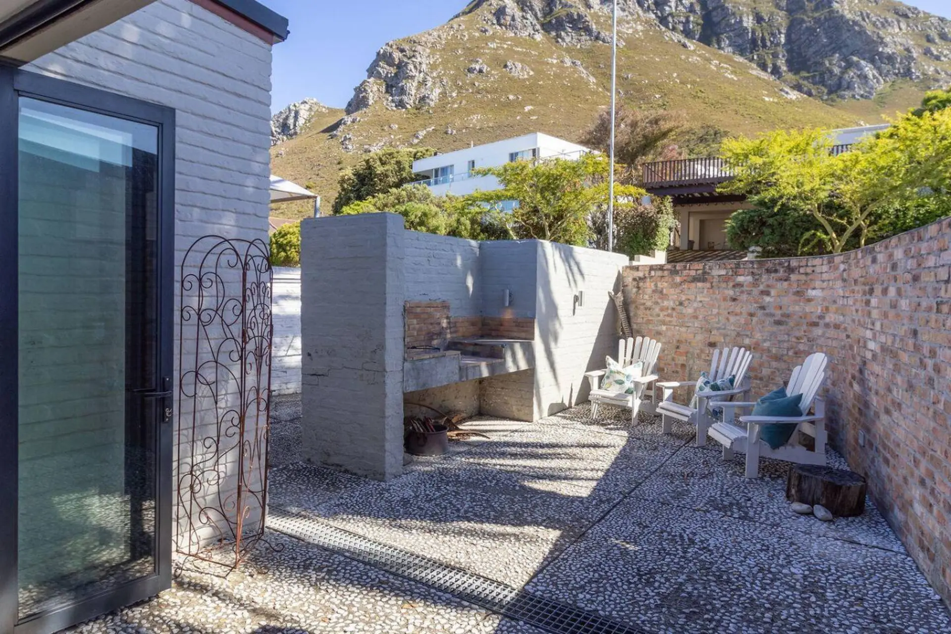 Outdoor patio with a built-in barbecue, chairs, and mountain views.