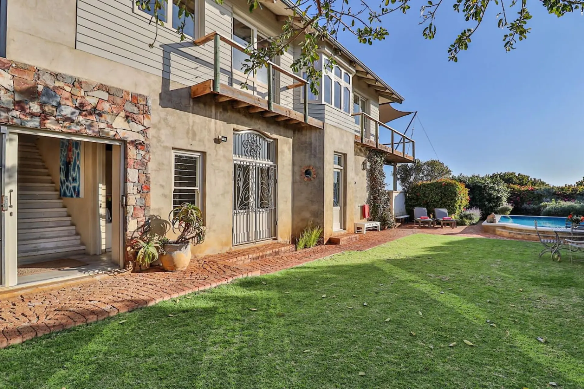 A large house with a pool and a well-kept lawn.