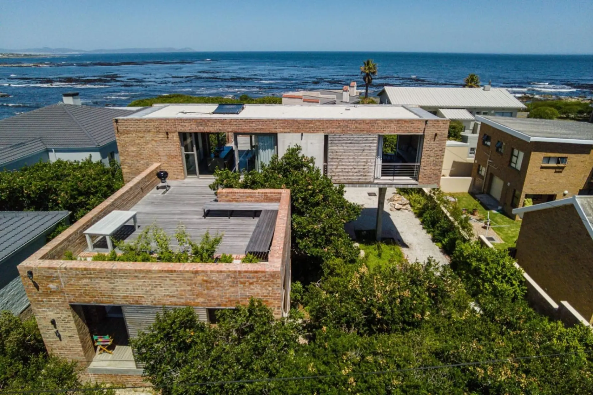 Modern brick home with rooftop deck and ocean views.