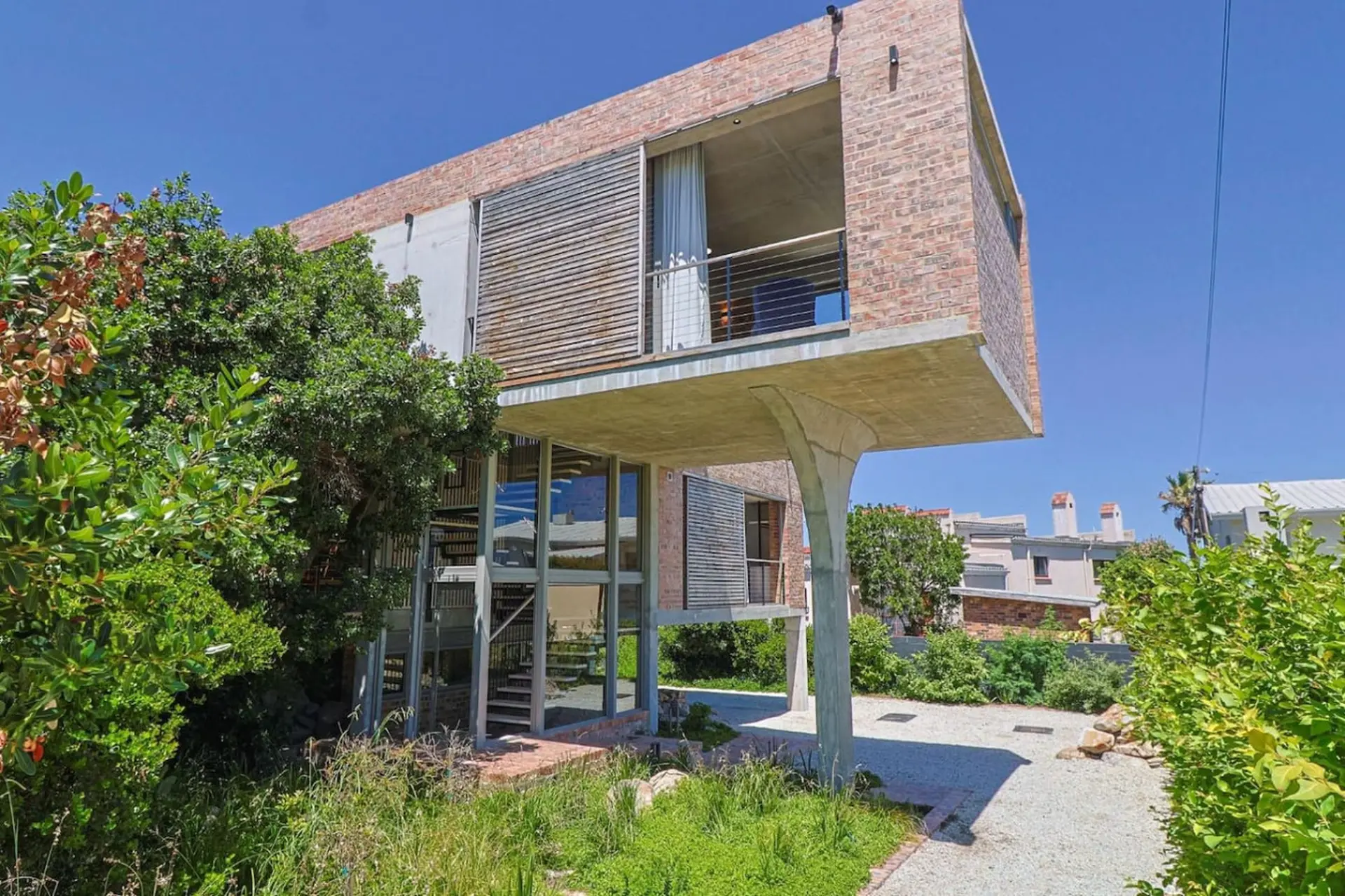 Modern brick house with cantilevered concrete floors and a spiral staircase.