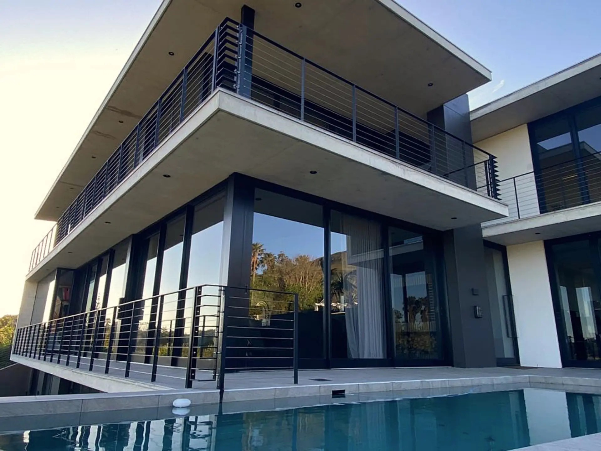 A modern house with multiple balconies and a swimming pool.