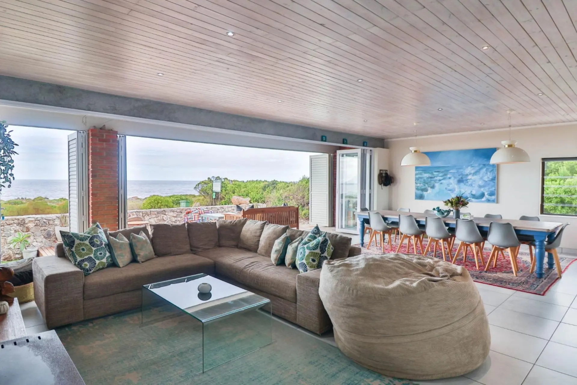 A spacious living and dining area with large windows and a sectional sofa.