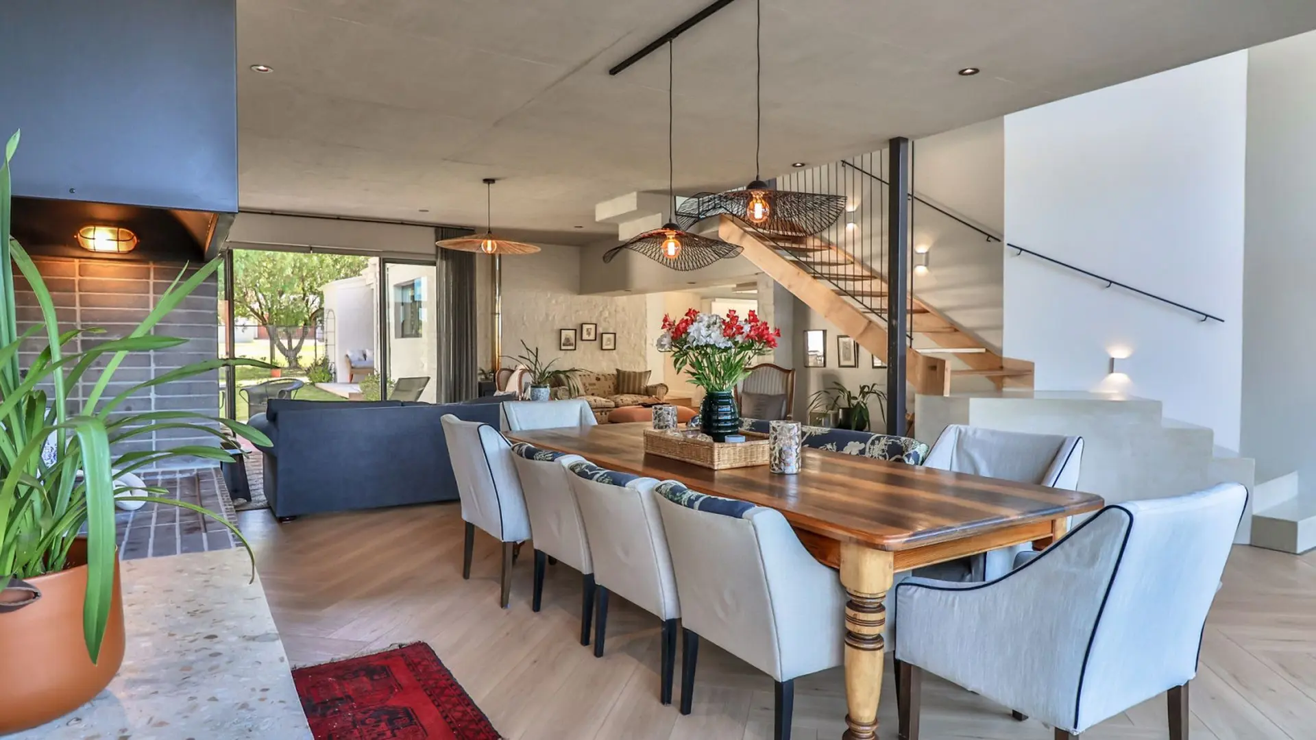 A dining room with a wooden table, chairs, and a fireplace.